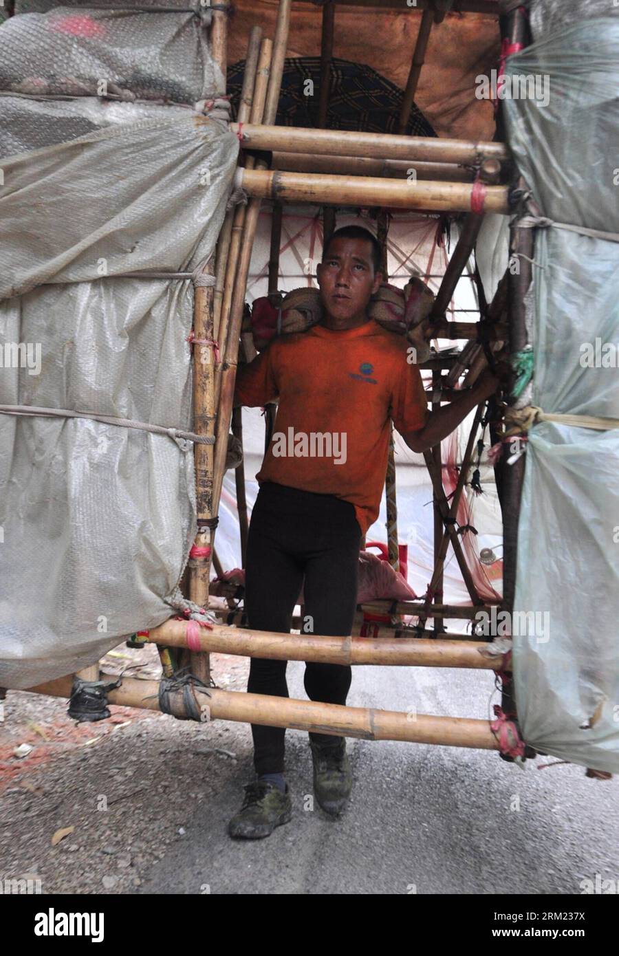 Bildnummer: 59677581  Datum: 21.05.2013  Copyright: imago/Xinhua LIUZHOU -- Liu Lingchao carries his moving hut on the 209 state highway in Liucheng County of Liuzhou City, south China s Guangxi Zhuang Autonomous Region, May 21, 2013. Liu, a 38-year-old migrant worker from Liuzhou s Rong an County, decided to make a moving hut five years ago in Guangdong Province to live in on his way to Rong an, his hometown. The hut measures about 60 kilograms in weight, 1.5 meters in length and 2.2 meters in height. Since then, Liu has been carrying a hut and making a living by collecting rubbishes along th Stock Photo