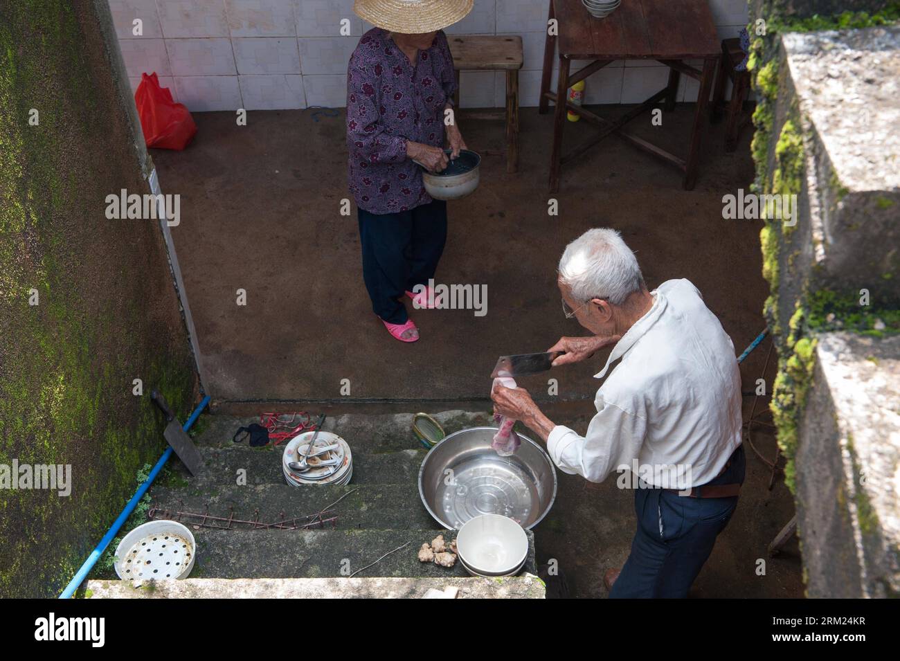 Bildnummer: 59691983  Datum: 24.05.2013  Copyright: imago/Xinhua (130524) -- JIAOLING, May 24, 2013 (Xinhua) -- Qiu Xianghai (R), 84, and his wife Lai Guixiang, 82, prepare for cooking in Hongxing Village of Jiaoling County, Meizhou City, South China s Guangdong Province, May 23, 2013. The couple has a son suffering from mental diseases and a daughter who lives far away from their house, leaving them self-dependent after the rainstorm hitting Guangdong Province on May 18. With the youth attending school or working outside their hometowns, the left-behind family members are becoming even more v Stock Photo