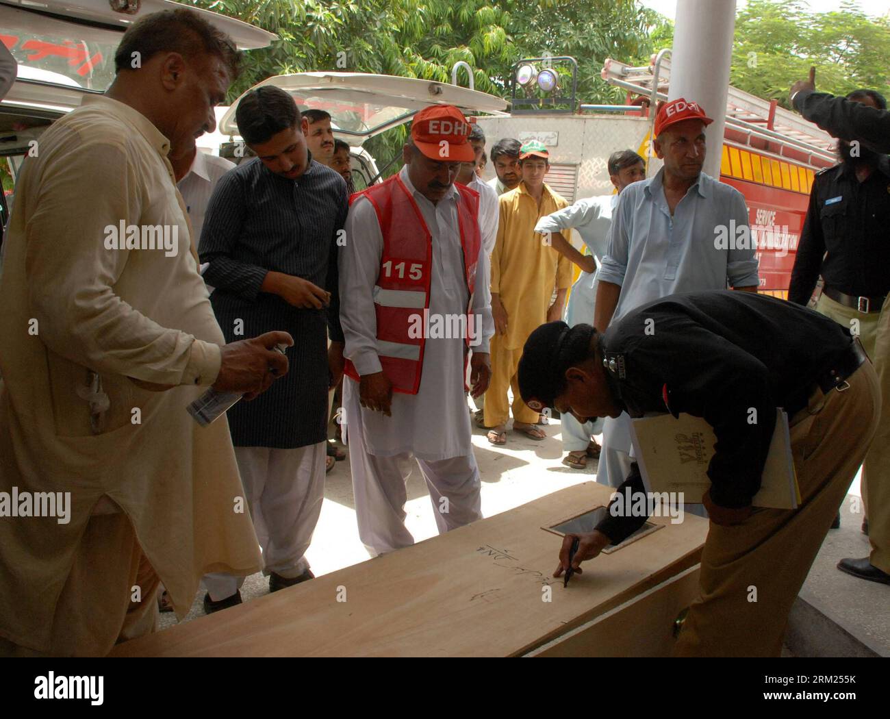 Bildnummer: 59700011  Datum: 25.05.2013  Copyright: imago/Xinhua (130525) -- GUJRAT (PAKISTAN), May 25, 2013 (Xinhua) -- A policeman writes a name on a coffin of a child who was killed in a school van gas cylinder blast on the outskirts of Gujrat, a district in Pakistan s eastern province of Punjab, on May 25, 2013. At least 15 children were killed in the school van gas cylinder blast that took place early Saturday morning in Gujrat, reported local media Dunya. (Xinhua/Stringer) (lr) PAKISTAN-GUJRAT-SCHOOL VAN GAS CYLINDER BLAST PUBLICATIONxNOTxINxCHN Gesellschaft Gasexplosion Schule Kind Opfe Stock Photo