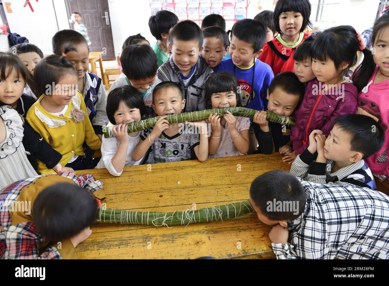 Bildnummer: 59736183  Datum: 30.05.2013  Copyright: imago/Xinhua Children gather to watch one-meter-long Zongzi, a kind of traditional food made of sticky rice and different fillings wrapped in bamboo or reed leaves, to celebrate the coming Dragon Boat Festival at Chengxia Village Kindergarten in Zhongshan Township of Tonglu County, east China s Zhejiang Province, May 30, 2013. (Xinhua/He Xiaohua) (lfj) CHINA-ZHEJIANG- SUPER LONG ZONGZI (CN) PUBLICATIONxNOTxINxCHN Gesellschaft xdp x0x 2013 quer     59736183 Date 30 05 2013 Copyright Imago XINHUA Children gather to Watch One Metres Long Zongzi Stock Photo