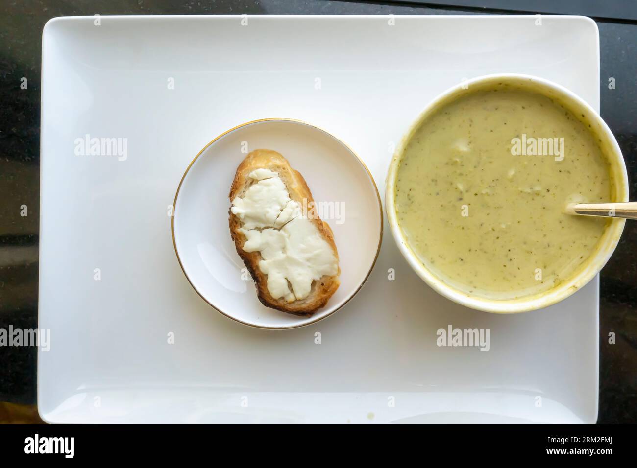 Creamy broccoli soup, served with baguette bread and goat cheese. Room service dining in Ritz