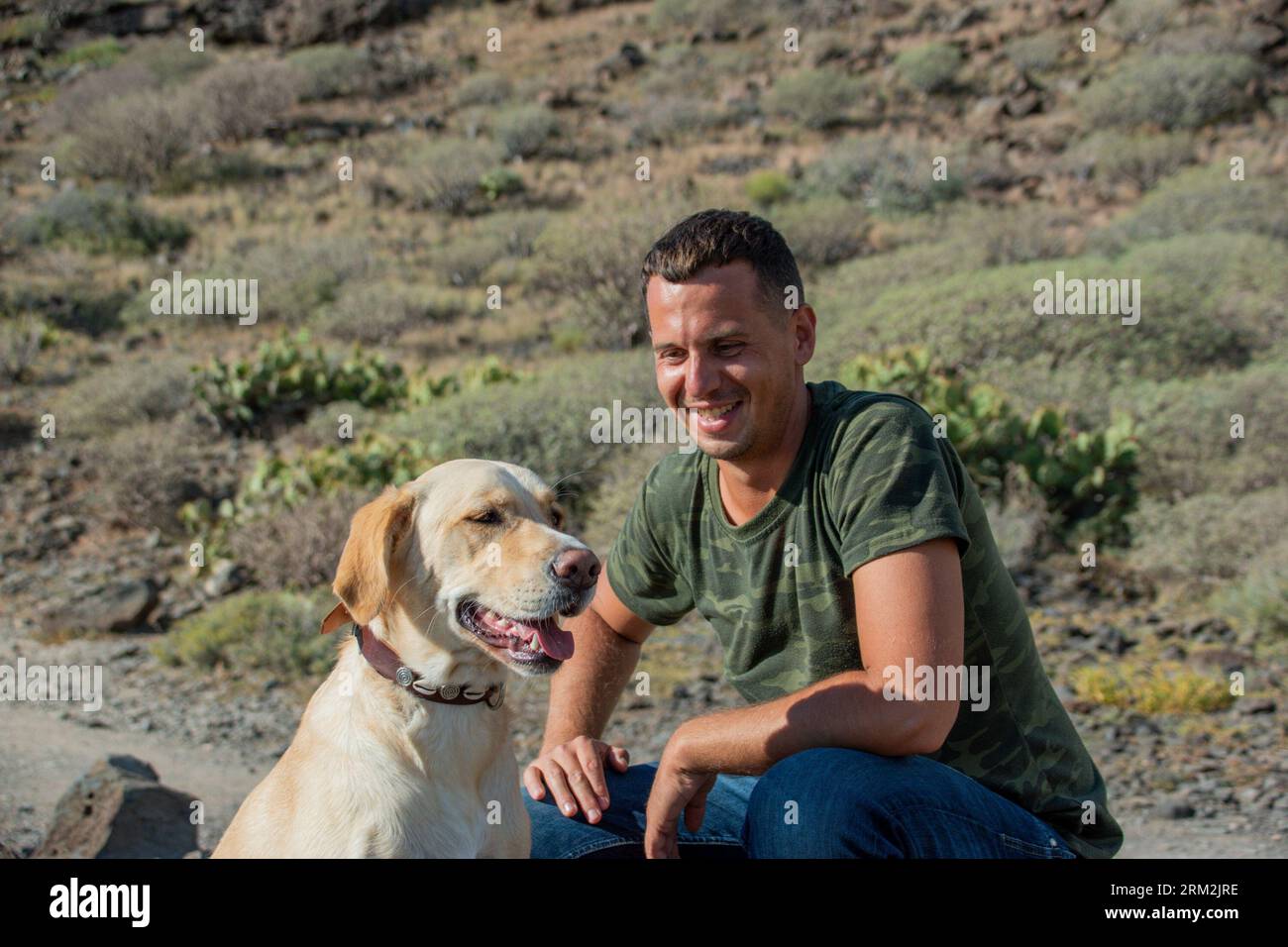 Canine trainer proudly looks at the labrador dog who diligently obeys his commands Stock Photo