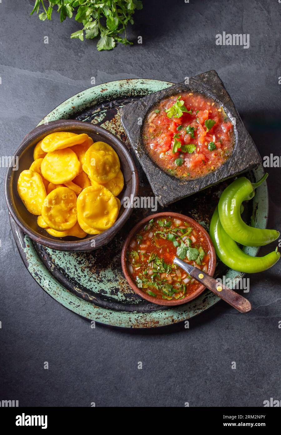 Sopaipilla. Latin American food. Traditional chilean homemade pumpkin sopaipillas with typical salsas - chancho en piedra tomato sauce in stone mortar Stock Photo