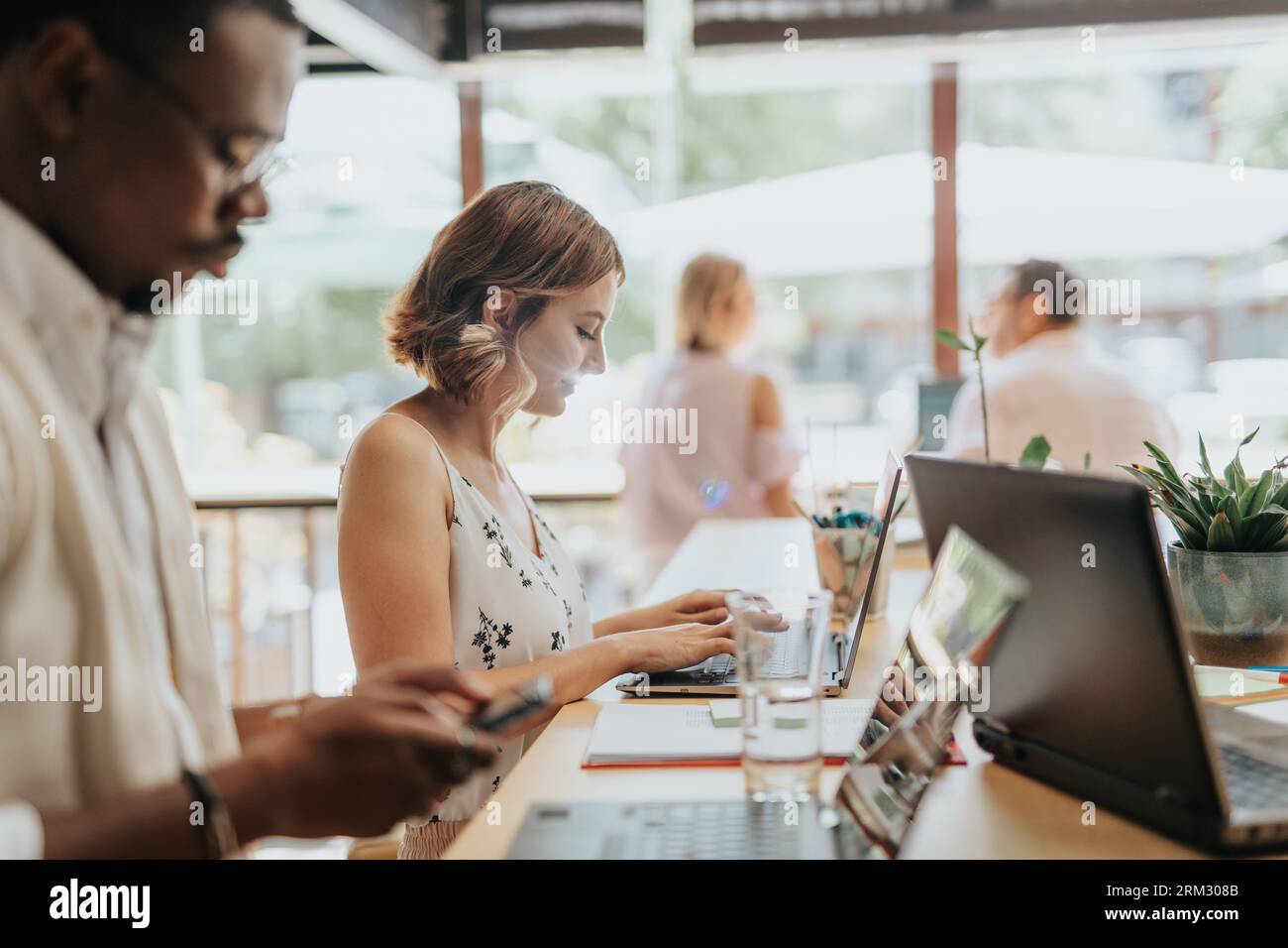 A multicultural group of businesspeople working together, analyzing statistics, discussing projects, and sharing innovative ideas for successful busin Stock Photo