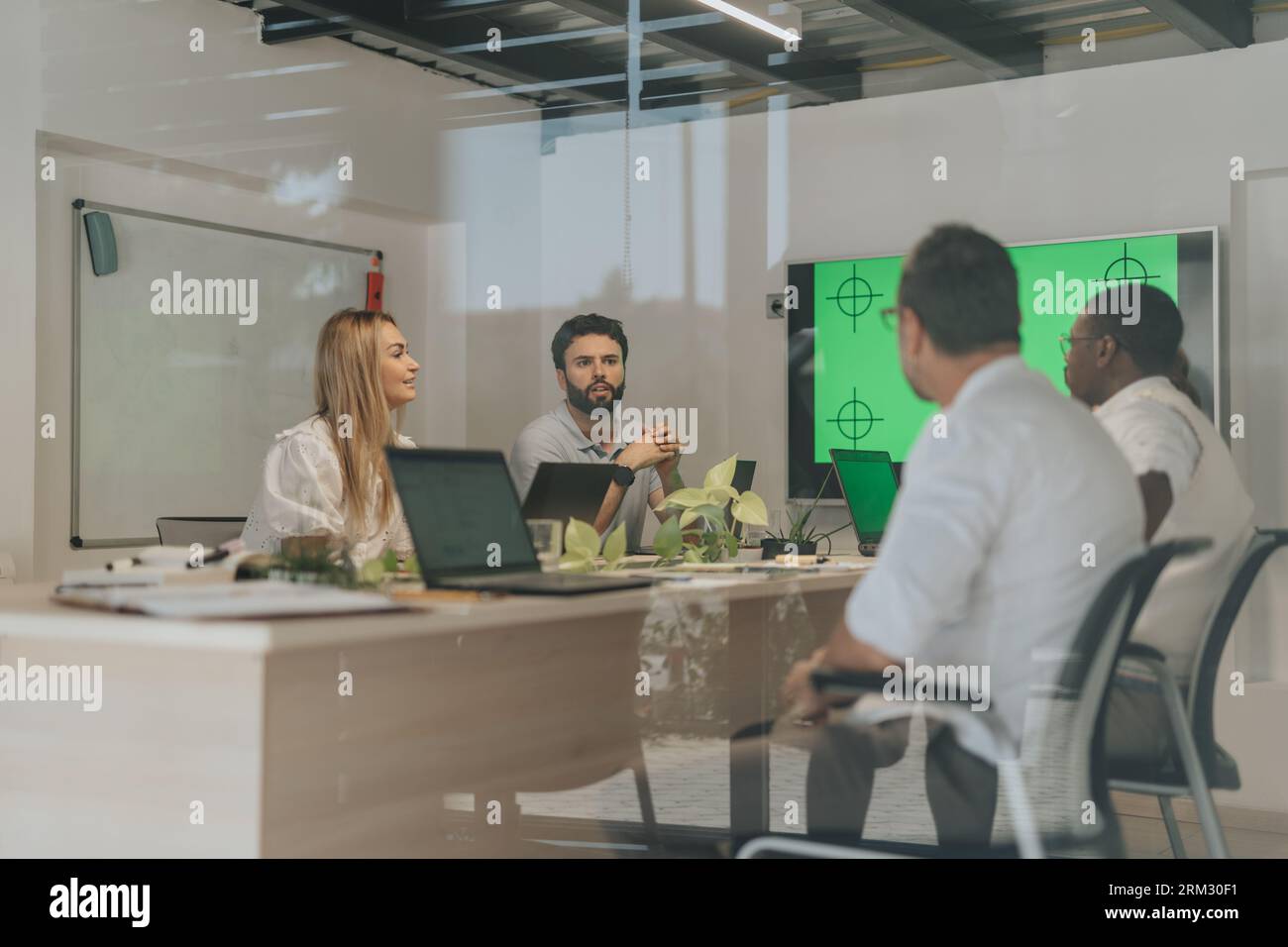 A diverse team of businesspeople collaborating in an office workspace, discussing and analyzing data to achieve profit growth and project development. Stock Photo