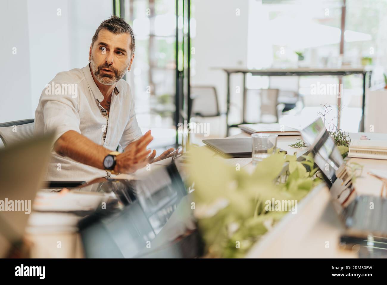 A diverse group of business professionals collaborating in an office, analyzing statistics and planning for profit growth. Stock Photo