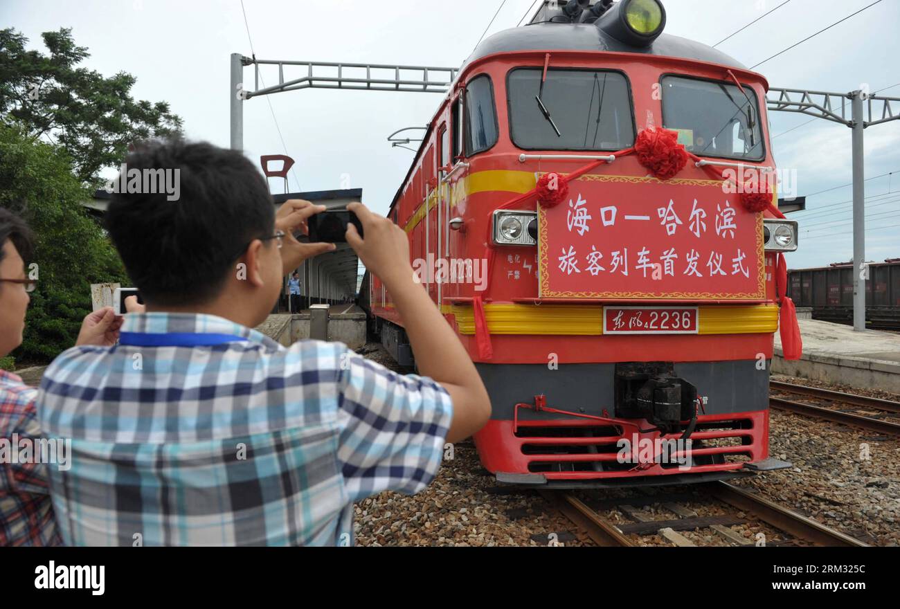 Bildnummer: 59930878  Datum: 02.07.2013  Copyright: imago/Xinhua (130702) -- HAIKOU, July 2, 2013 (Xinhua) -- Passengers take photos of the locomotive of the first direct train from Haikou to Harbin at Haikou Railway Station in Haikou, capital of south China s Hainan Province, July 2, 2013. The train K1122/3 from south China s Haikou to northeast China s Heilongjiang left Haikou Tuesday, a day later than its original departure date due to the tropical storm Rumbia. The train which travels 4,458 kilometers for 65 hours has connected China s southernmost capital city Haikou of Hainan Province wi Stock Photo