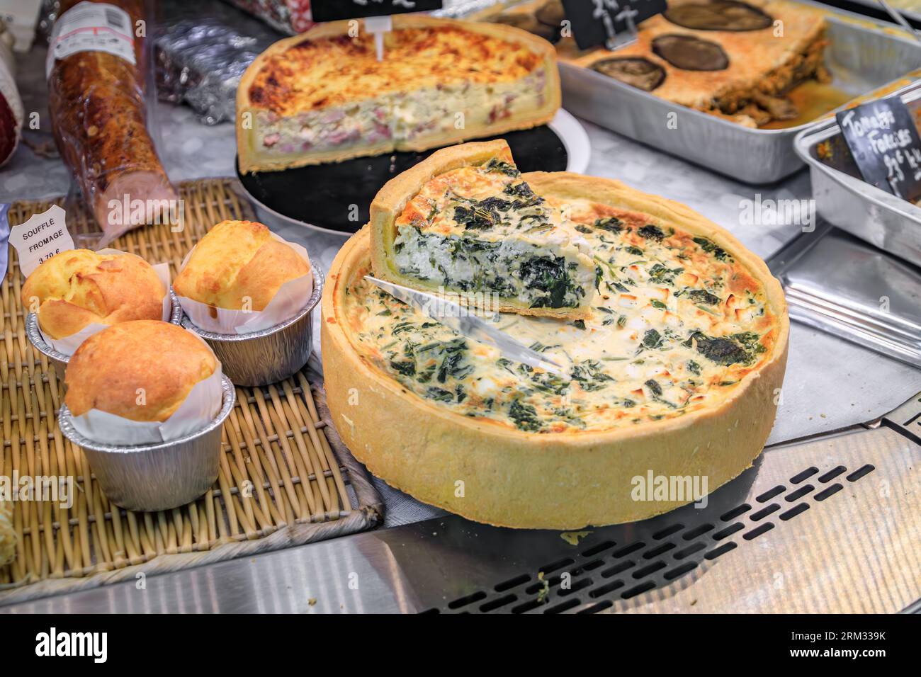 Quiche with spinach, quiche lorraine with ham and cheese, cheese souffle at a farmers market in the Old Town Menton, French Riviera, South of France Stock Photo