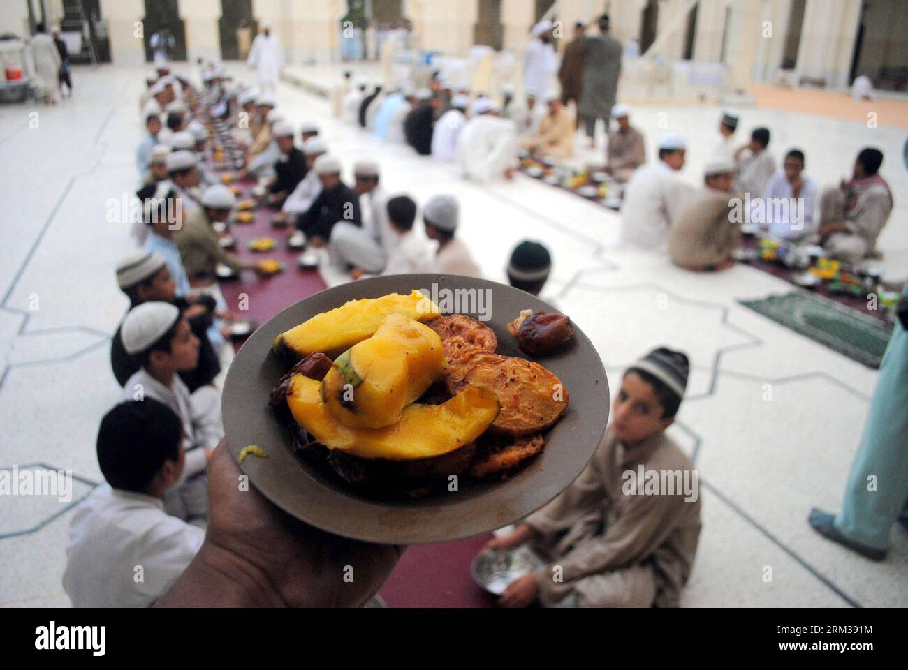 Bildnummer: 60111927  Datum: 11.07.2013  Copyright: imago/Xinhua (130711) -- PESHAWAR, July 11, 2013 (Xinhua) -- A Pakistani volunteer distributes Iftar for Muslim devotees at a mosque during the first day of the Muslim fasting month of Ramadan in northwest Pakistan s Peshawar on July 11, 2013. Iftar refers to the evening meal when Muslims break their fast during the holly month of Ramadan, a season of fasting and spiritual reflection. (Xinhua/Umar Qayyum) PAKISTAN-PESHAWAR-RAMADAN-IFTAR PUBLICATIONxNOTxINxCHN Gesellschaft Religion Islam Muslim Ramadan Fasten Fastenmonat Iftar Fastenbrechen Fe Stock Photo