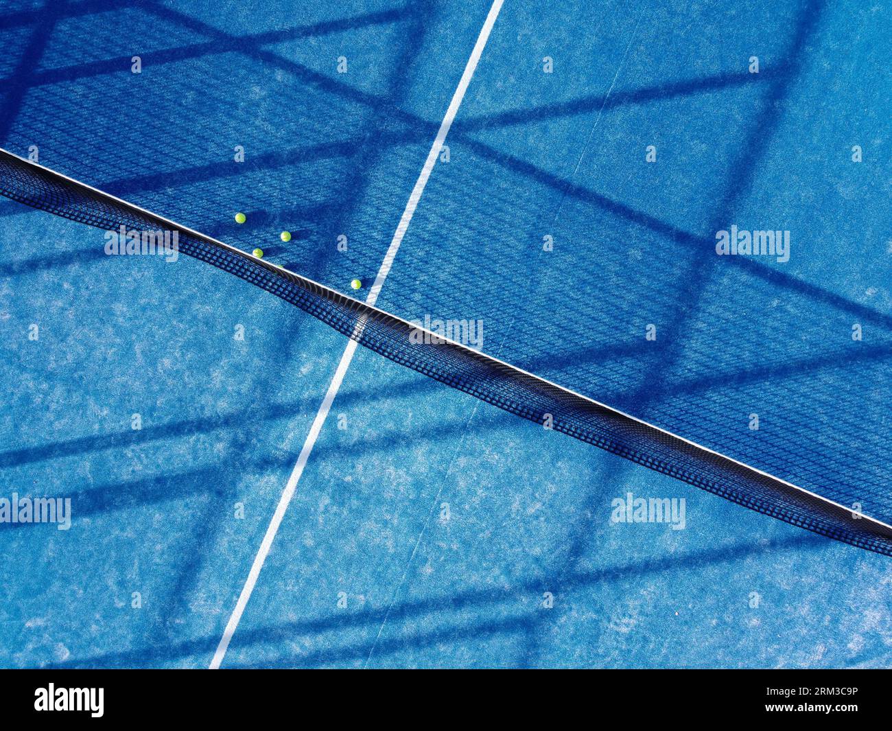 aerial zenithal image of five balls on a blue artificial grass paddle tennis court Stock Photo