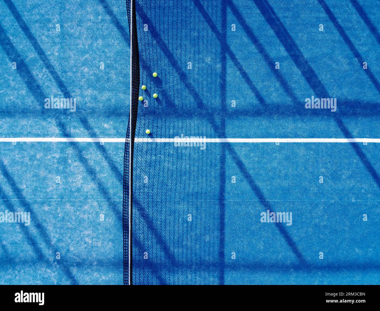 aerial top image of five balls near the net on a blue artificial grass paddle tennis court Stock Photo