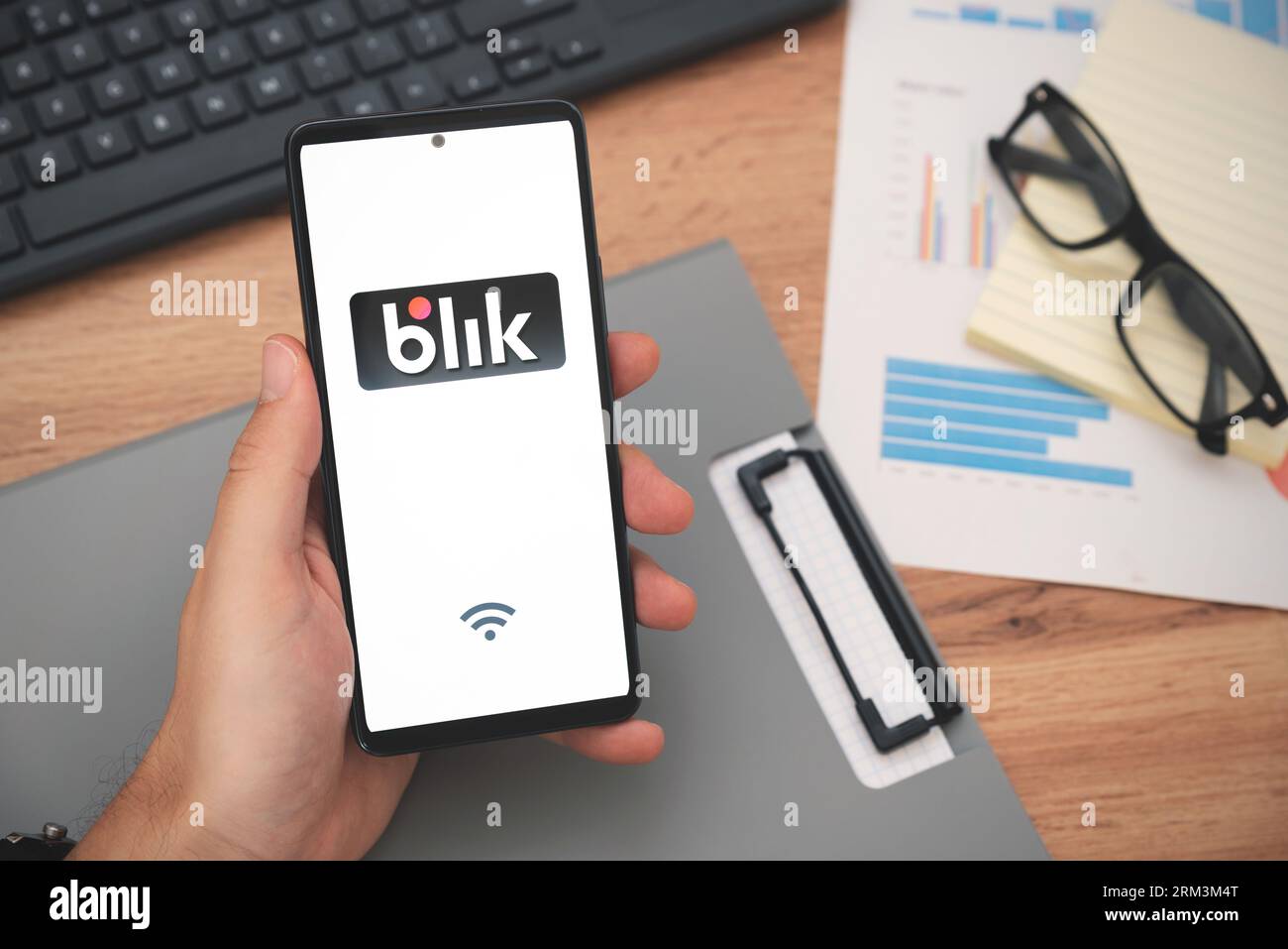 Wroclaw, Poland - AUG 24, 2023: Man holding smartphone with Blik logo, contactless payment. Blik is Polish most popular quick payment method in Poland Stock Photo