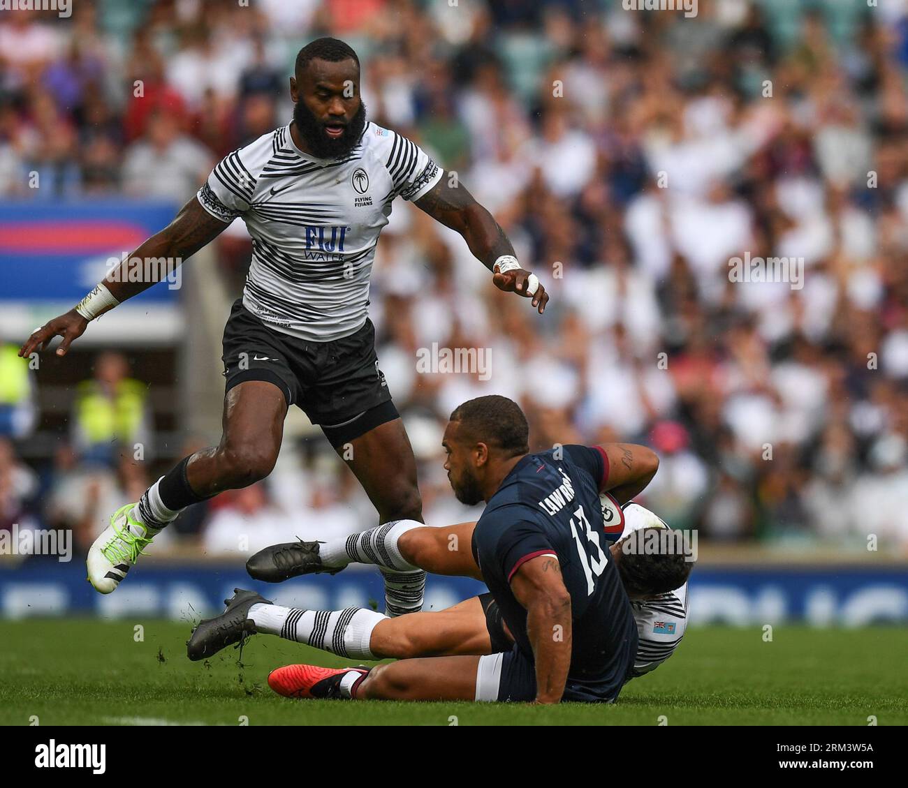 Ollie Lawrence of England tackled by Caleb Muntz of Fiji and Semi