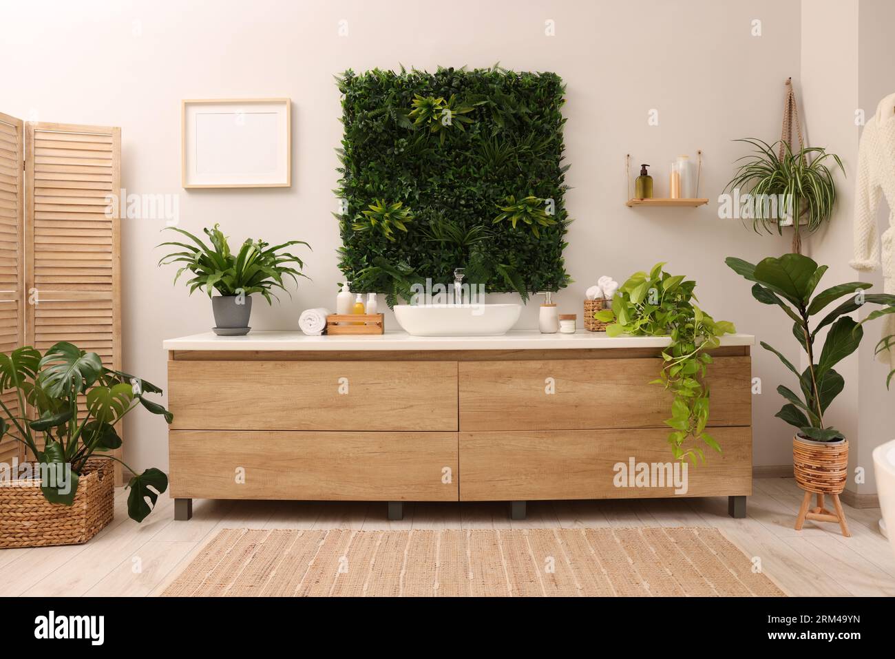 Green artificial plants, vanity and different personal care products in  bathroom Stock Photo - Alamy