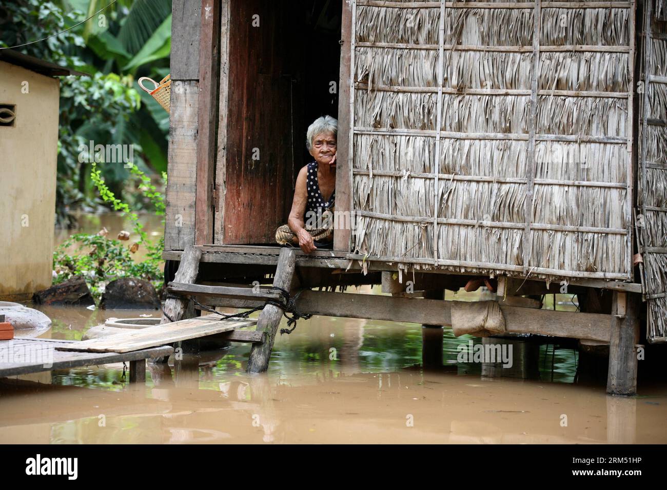 Bildnummer: 60549800  Datum: 01.10.2013  Copyright: imago/Xinhua (131001) -- PHNOM PENH, Oct. 1, 2013 (Xinhua) -- A woman sits inside her flooded house in southern Cambodia s Kandal province, Oct. 1, 2013. At least 30 in Cambodia have died of drowning in less than three weeks due to Mekong River and flash floods, Keo Vy, chief of the Cabinet of the National Committee for Disaster Management, said. The floods have forced more than 9,000 families to flee their homes and inundated nearly 100,000 hectares of rice paddy. (Xinhua/Phearum) CAMBODIA-KANDAL-FLOOD PUBLICATIONxNOTxINxCHN Gesellschaft Hoc Stock Photo