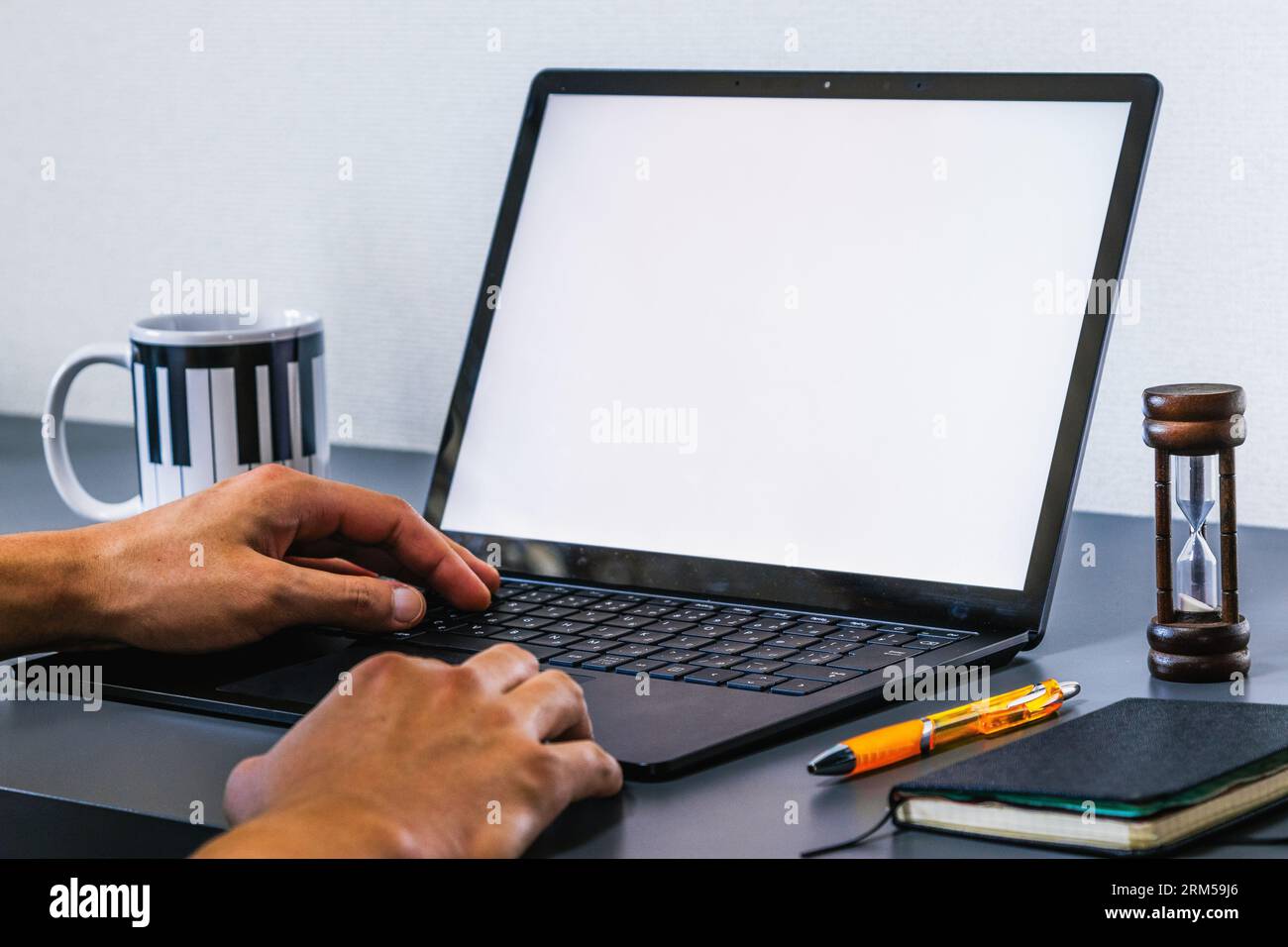 Aluno estudando a distância, trabalho em casa, escritório. Jovem usando um laptop, mão no teclado. gSimular a vizualização de tela. Stock Photo