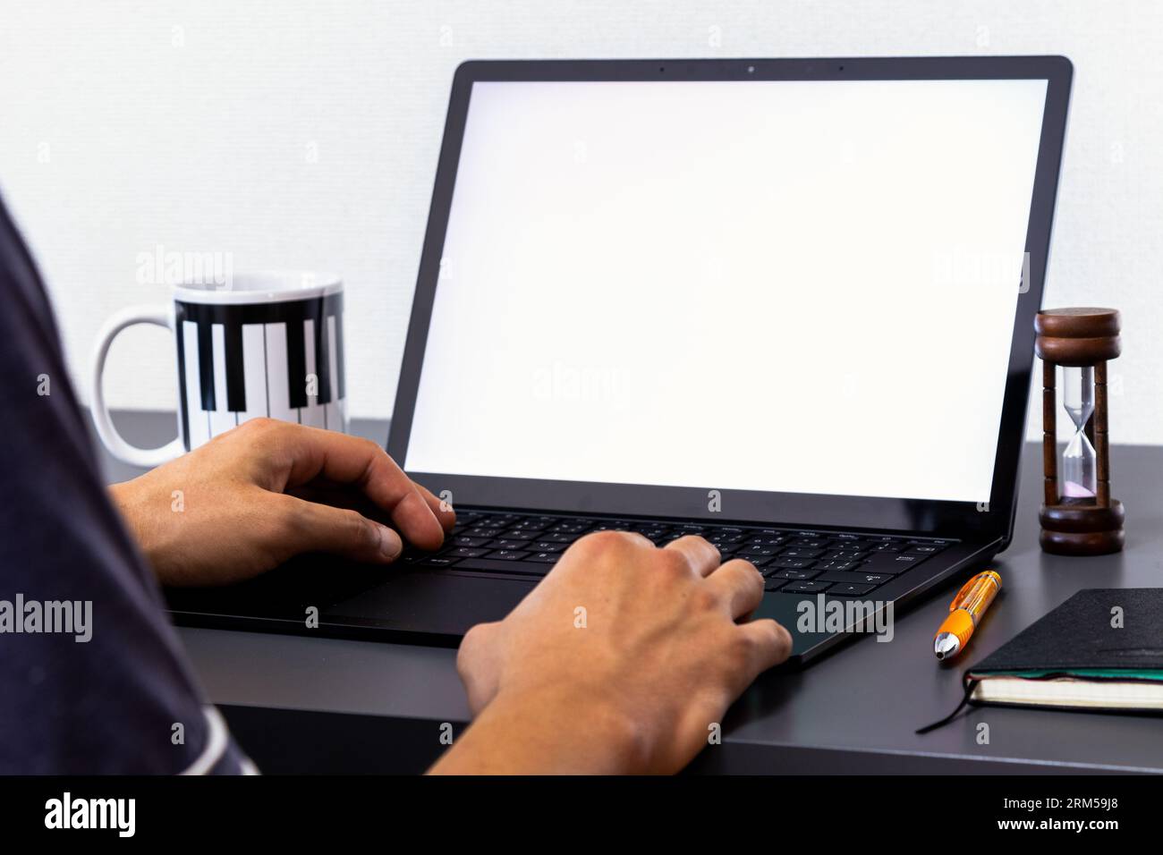 Aluno estudando a distância, trabalho em casa, escritório. Jovem usando um laptop, mão no teclado. gSimular a vizualização de tela. Stock Photo