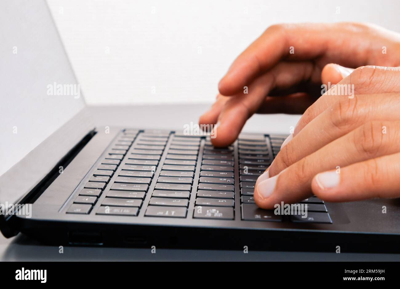 Aluno estudando a distância, trabalho em casa, escritório. Jovem usando um laptop, mão no teclado. Simular a vizualização de tela. Close-up. Stock Photo