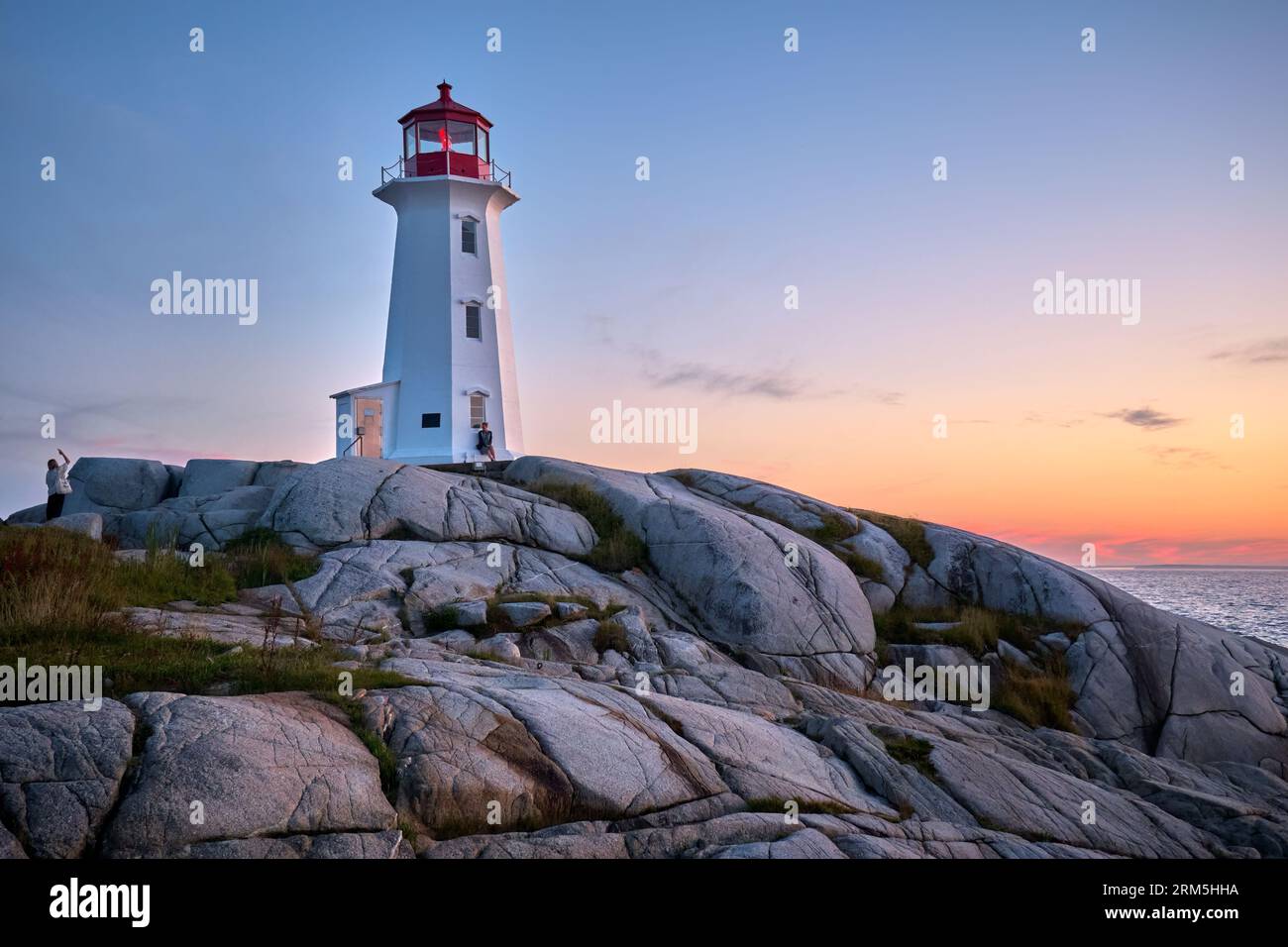 Visitors enjoying the sunset at Peggys Cove Nova Scotia. Stock Photo