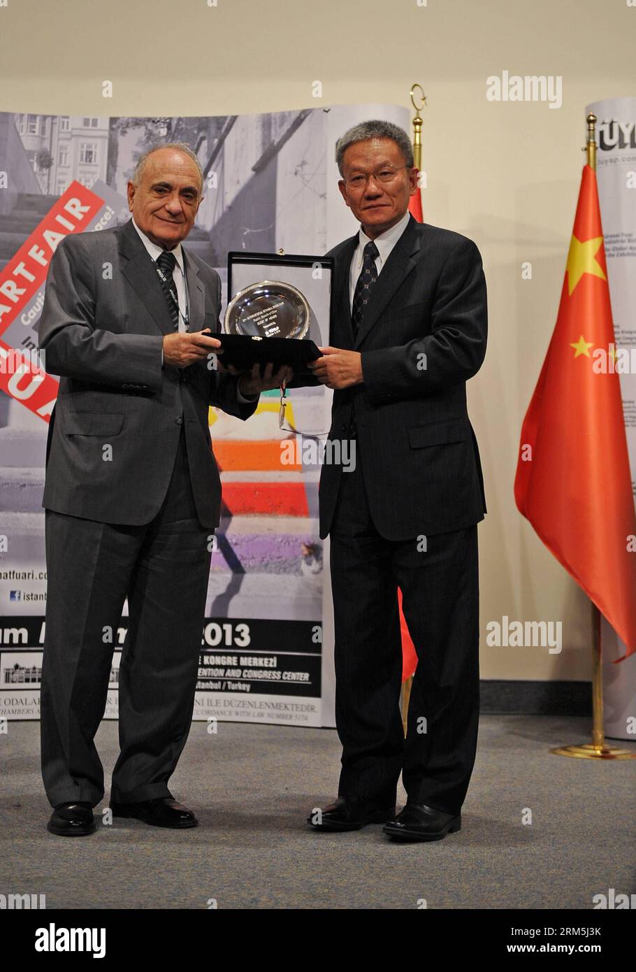 Bildnummer: 60668121  Datum: 02.11.2013  Copyright: imago/Xinhua CEO of Tuyap Bulent Unal presents a souvenir to Wu Shulin, deputy director of the General Administration of Press and Publications of China during the opening ceremony of the 32nd International Istanbul Book Fair in Istanbul, Turkey, on Nov. 2, 2013. The 32nd International Istanbul Book Fair opened here on Saturday. More than 650 publishers from 40 countries and regions attended the 9-day fair. China is the country of honor for the event. (Xinhua/Lu Zhe) (dzl) TURKEY-ISTANBUL-BOOK FAIR PUBLICATIONxNOTxINxCHN Wirtschaft Messe x0x Stock Photo