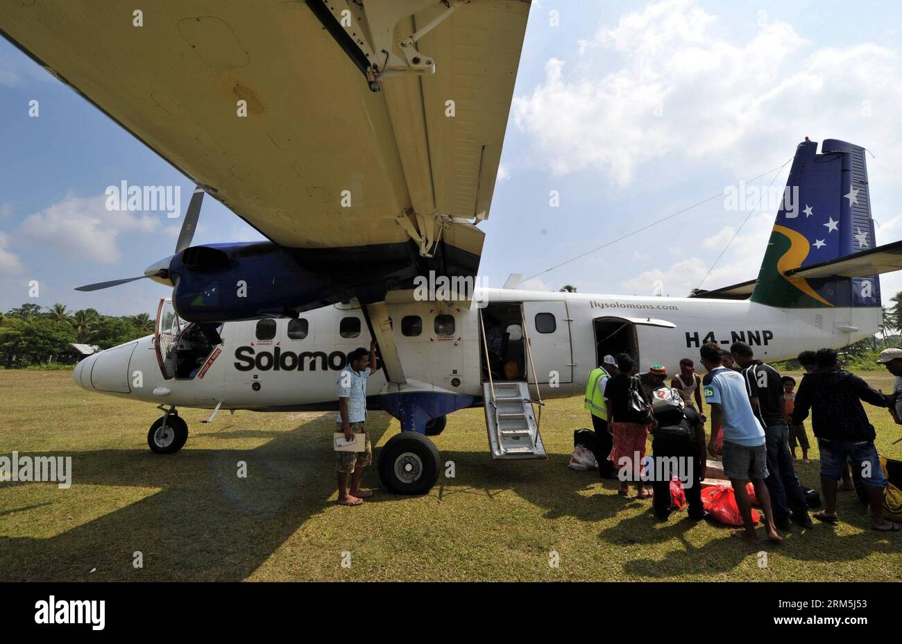 Bildnummer: 60668794  Datum: 02.11.2013  Copyright: imago/Xinhua Passengers get their luggages from a Twin Otter lightplane which has served 30 years at the airport of Rennell in Solomon Islands, Nov. 2, 2013. The Solomon Airlines owns a history of more than 50 years. The DHC 8-102 , Twin Otter and Islander are three kinds of vintage lightplanes serving for national flights which can respectively carry 36, 16 and 9 passengers. Most of these planes have served more than ten years or even dozens of years. (Xinhua/Gao Jianjun) SOLOMON ISLANDS-SOLOMON AIRLINES-VINTAGE LIGHTPLANES PUBLICATIONxNOTxI Stock Photo
