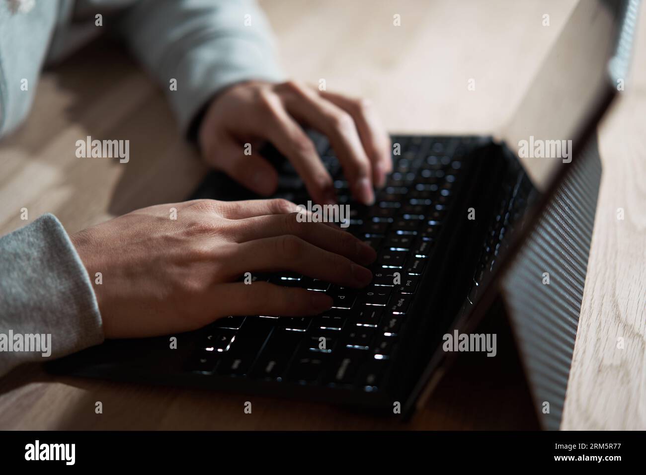 Male hacker hitting text on a laptop Stock Photo