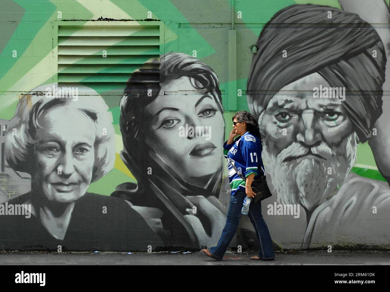 Bildnummer: 60761576  Datum: 26.11.2013  Copyright: imago/Xinhua     VANCOUVER, Nov. 26, 2013 - A woman walks past a wall with graffiti art in Vancouver, Canada, Nov. 26, 2013. For the second year in a row, Seattle-based walk ability ranking company Walk Score named Vancouver as the most walkable city in Canada. (Xinhua/Sergei Bachlakov) (zhf) CANADA-VANCOUVER-WALKABLE CITY PUBLICATIONxNOTxINxCHN Gesellschaft x2x xkg 2013 quer o0 Kunst Kultur Wandmalerei Land Leute Vancouver Canucks Trikot Stock Photo