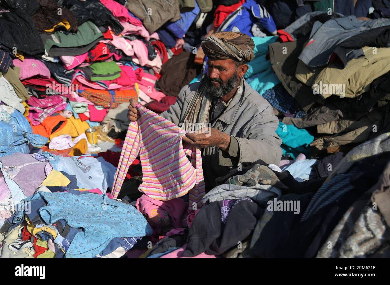 Bildnummer: 60765247  Datum: 28.11.2013  Copyright: imago/Xinhua     (131128) -- Ghazni, Nov. 28, 2013. (Xinhua) -- An Afghan street vender displays clothes for sells in Ghanzi province in eastern of Afghanistan on Nov. 28, 2013. (Xinhua/Rahmat)(lrz) AFGHANISTAN-GHANZI-DAILY LIFE PUBLICATIONxNOTxINxCHN xcb x0x 2013 quer Stock Photo