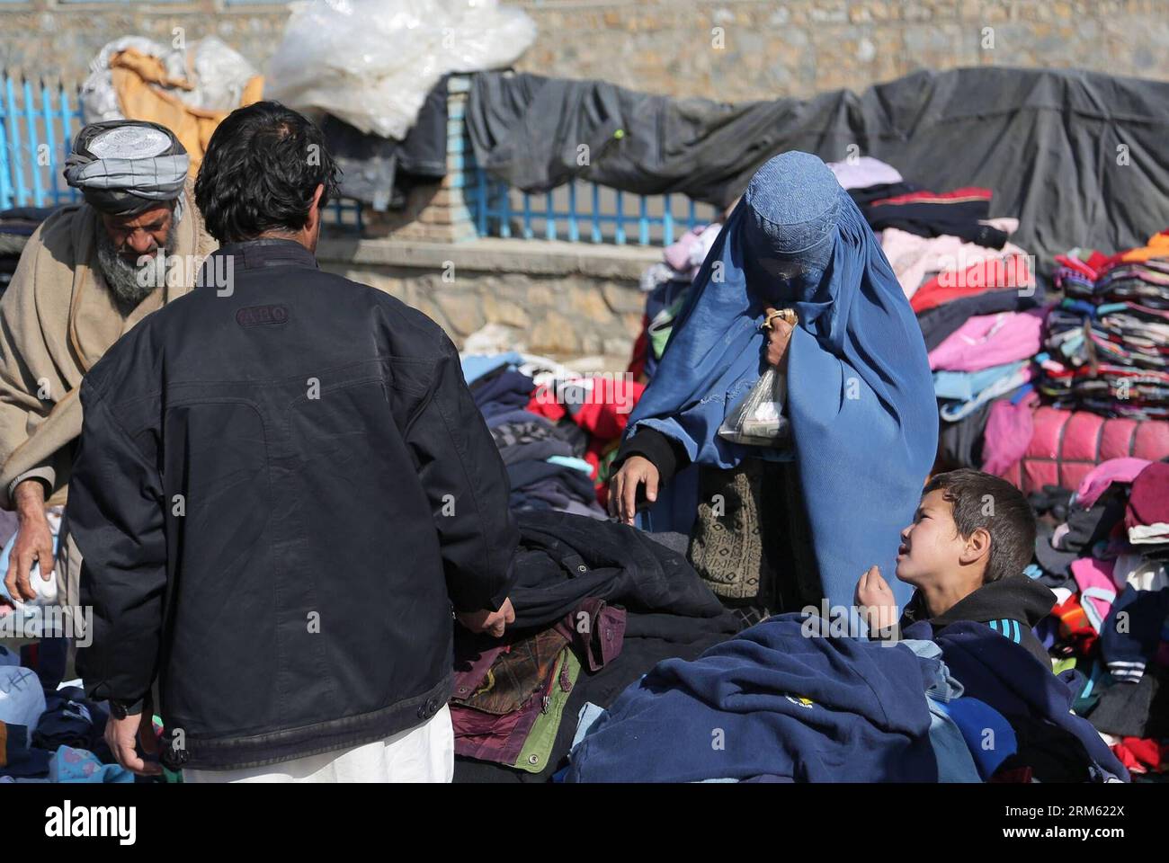 Bildnummer: 60765248  Datum: 28.11.2013  Copyright: imago/Xinhua     (131128) -- Ghazni, Nov. 28, 2013. (Xinhua) -- An Afghan woman buys clothes from a street vender in Ghanzi province in eastern Afghanistan on Nov. 28, 2013. (Xinhua/Rahmat)(lrz) AFGHANISTAN-GHANZI-DAILY LIFE PUBLICATIONxNOTxINxCHN xcb x0x 2013 quer Stock Photo