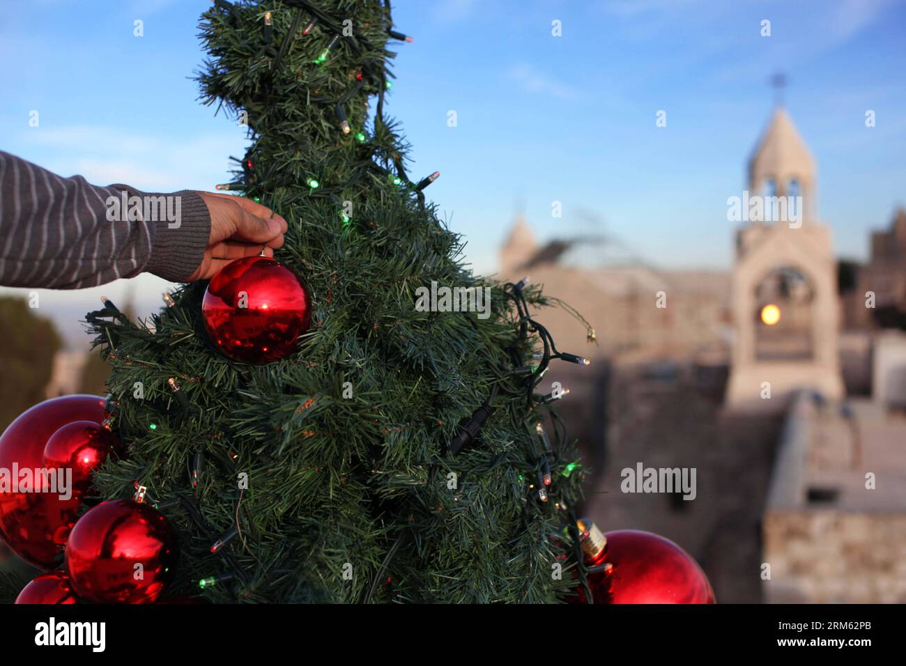Bildnummer: 60775425  Datum: 30.11.2013  Copyright: imago/Xinhua     A worker puts final touches on a huge Christmas tree erected near the Church of the Nativity in the West Bank city of Bethlehem on Nov. 30, 2013. (Xinhua/Luay Sababa) MIDEAST-BETHLEHEM-CHRISTMAS TREE PUBLICATIONxNOTxINxCHN xcb x0x 2013 quer Stock Photo