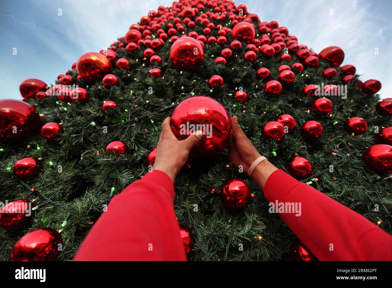Bildnummer: 60775423  Datum: 30.11.2013  Copyright: imago/Xinhua     A worker puts final touches on a huge Christmas tree erected near the Church of the Nativity in the West Bank city of Bethlehem on Nov. 30, 2013. (Xinhua/Luay Sababa) MIDEAST-BETHLEHEM-CHRISTMAS TREE PUBLICATIONxNOTxINxCHN xcb x0x 2013 quer Stock Photo