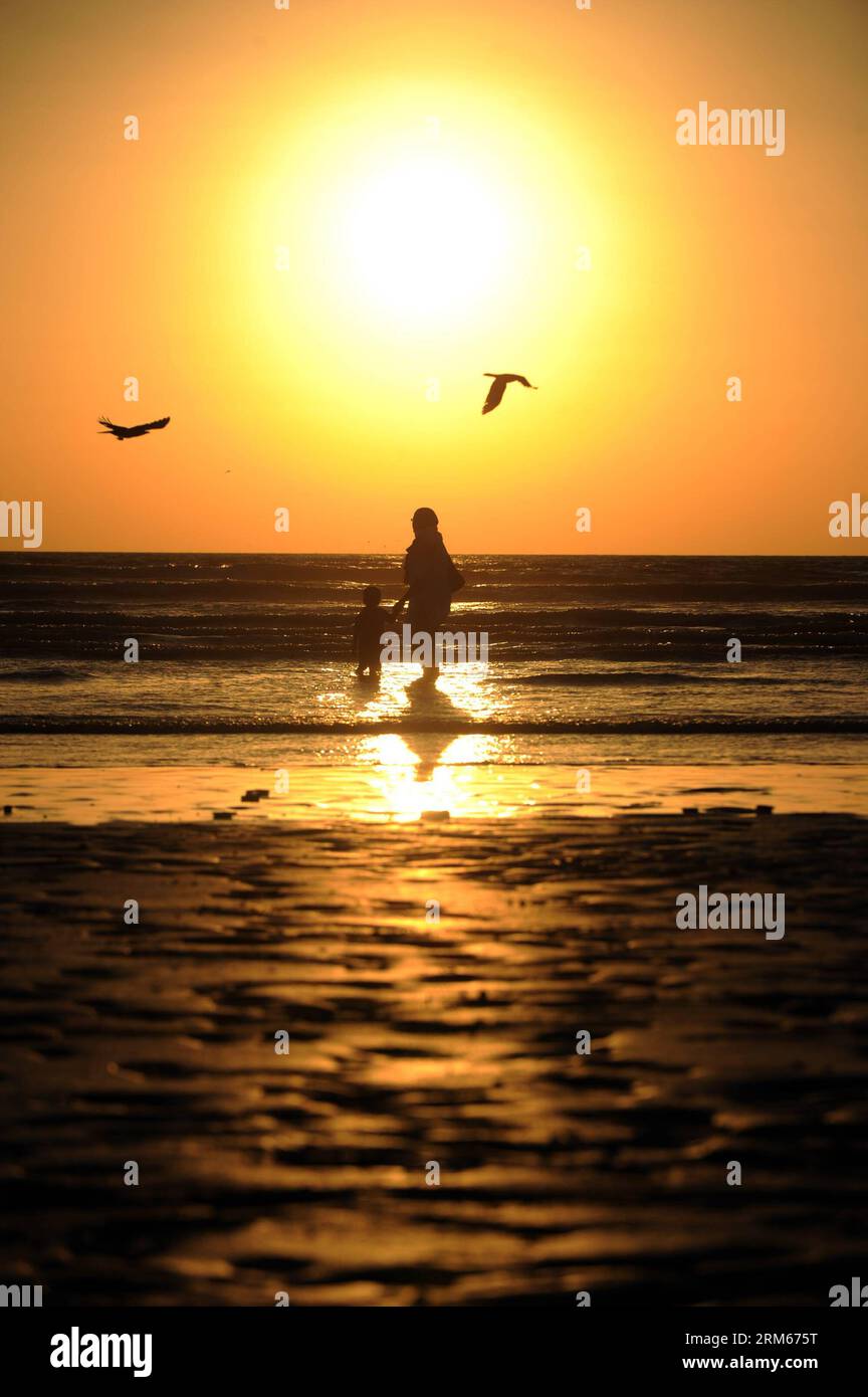 Bildnummer: 60831514  Datum: 14.12.2013  Copyright: imago/Xinhua     A mother and her son stand on a beach to view sunset in Karachi, Pakistan, on Dec. 14, 2013. (Xinhua/Huang Zongzhi) PAKISTAN-KARACHI-SUNSET PUBLICATIONxNOTxINxCHN xcb x0x 2013 hoch Stock Photo