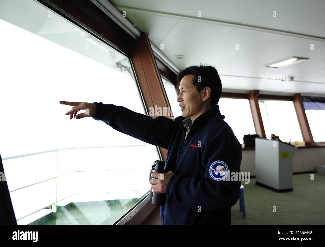 (131228) -- ABOARD XUELONG, Dec. 28, 2013 (Xinhua) -- Wang Jianzhong, captain of Xuelong, observes the weather condition on Chinese icebreaker Xuelong, or Snow Dragon, Dec. 28, 2013. Chinese icebreaker Xuelong, or Snow Dragon, on way to rescue a Russian science ship trapped off Antarctica, has stalled itself since midnight Friday after getting stuck in thick ice only 6.1 nautical miles away from the Russian ship. (Xinhua/Zhang Jiansong) (yxb) CHINA-30TH ANTARCTIC EXPEDITION-ICEBREAKER (CN) PUBLICATIONxNOTxINxCHN   Aboard XUELONG DEC 28 2013 XINHUA Wang Jianzhong Captain of XUELONG observes The Stock Photo