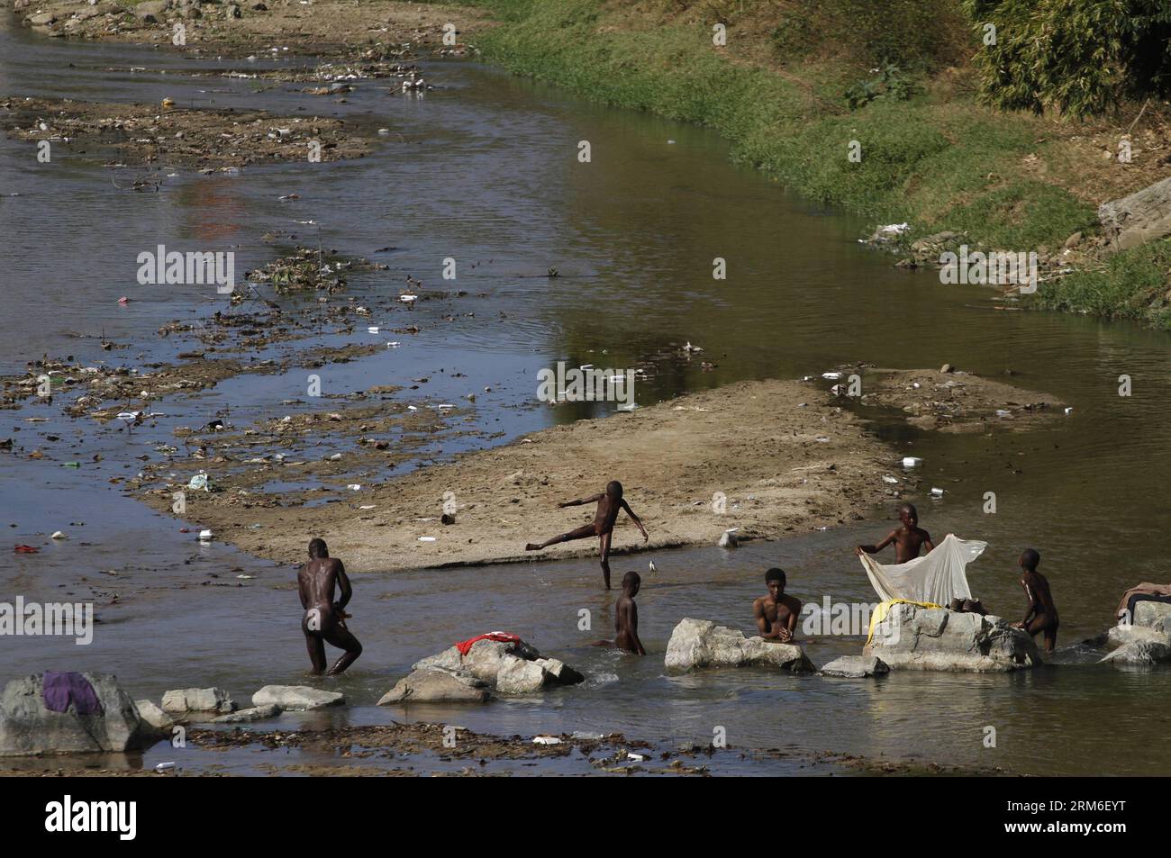(140108) -- OUANAMINTHE,  (Xinhua) -- Haitians take bath in the Masacre or Dajabon river on the border of Haiti and Dominican Republic in the city of Ouanaminthe, 317 km northeast from Port-au-Prince, Haiti s capital, on Jan. 7, 2014. Haiti and Dominican Republic on Tuesday resumed issues related to migration, trade, border security and regulation of binational markets, confirmed by both countries. Haiti recognized the sovereign right of Dominican Republic to determine its immigration policy and naturalization requirements, although requested guarantees to protect the basic rights of Haitian d Stock Photo