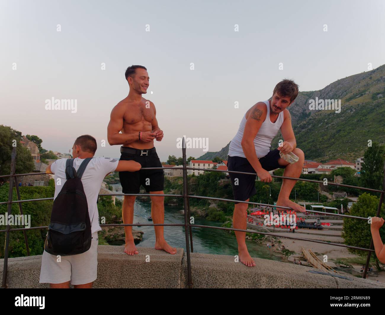 Locals stand on Stari Most (Old Bridge) with Neretva River below on a summers evening in Mostar, Bosnia and Herzegovina, August 22, 2023. Stock Photo