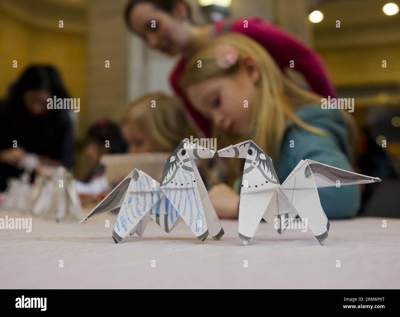 Kids learn to fold paper horse during the 2014 Chinese New Year Extravaganza at the Royal Ontario Museum in Toronto, Canada, Jan. 25, 2014. The event provided an opportunity for Canadians to learn about Chinese culture while celebrating the coming Lunar New Year of the Horse, which begins on Jan. 31. (Xinhua/Zou Zheng) (hy) CANADA-TORONTO-CHINESE NEW YEAR PUBLICATIONxNOTxINxCHN   Kids Learn to Fold Paper Horse during The 2014 Chinese New Year  AT The Royal Ontario Museum in Toronto Canada Jan 25 2014 The Event provided to Opportunity for Canadians to Learn About Chinese Culture while Celebrati Stock Photo