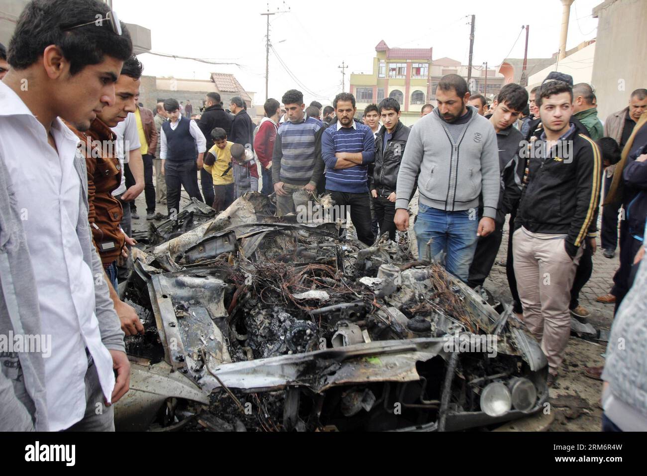 (140126) -- KIRKUK, Jan. 26, 2014 (Xinhua) -- People gather around a damaged vehicle at the blast site in Kirkuk, Iraq, on Jan. 26, 2014. At least four people were killed and 14 wounded in the afternoon when three car bombs detonated almost simultaneously in separate neighborhoods in the city of Kirkuk, some 250 km north of the Iraqi capital of Baghdad, a local police source told Xinhua on condition of anonymity. (Xinhua/Dena Assad) (zjl) IRAQ-KIRKUK-BLAST PUBLICATIONxNOTxINxCHN   Kirkuk Jan 26 2014 XINHUA Celebrities gather Around a damaged Vehicle AT The Blast Site in Kirkuk Iraq ON Jan 26 2 Stock Photo