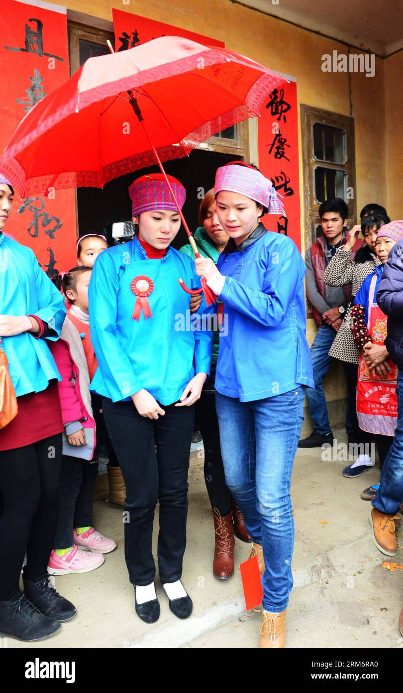 (140126) -- FUCHUAN, Jan. 26, 2014 (Xinhua) -- Bride Nie Changying (L front), accompanied by a bridesmaid, leaves her home for wedding in Wujia Village, Gucheng Township, Fuchuan Yao Autonomous County, south China s Guangxi Zhuang Autonomous Region, Jan. 25, 2014. As a member of the Yao ethnic group, the 26-year-old bride chose to get married by the Yao tradition on Saturday. (Xinhua/Chen Zixia) (hdt) CHINA-FUCHUAN-ETHNIC WEDDING (CN) PUBLICATIONxNOTxINxCHN   Fuchuan Jan 26 2014 XINHUA Bride never  l Front accompanied by a bridesmaid Leaves her Home for Wedding in  Village Gucheng Township Fuc Stock Photo