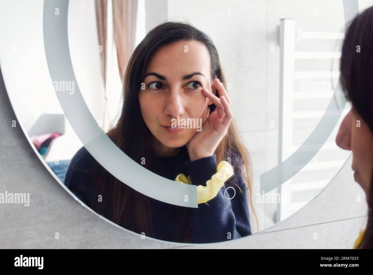 An attractive white Caucasian young woman looking in the bathroom