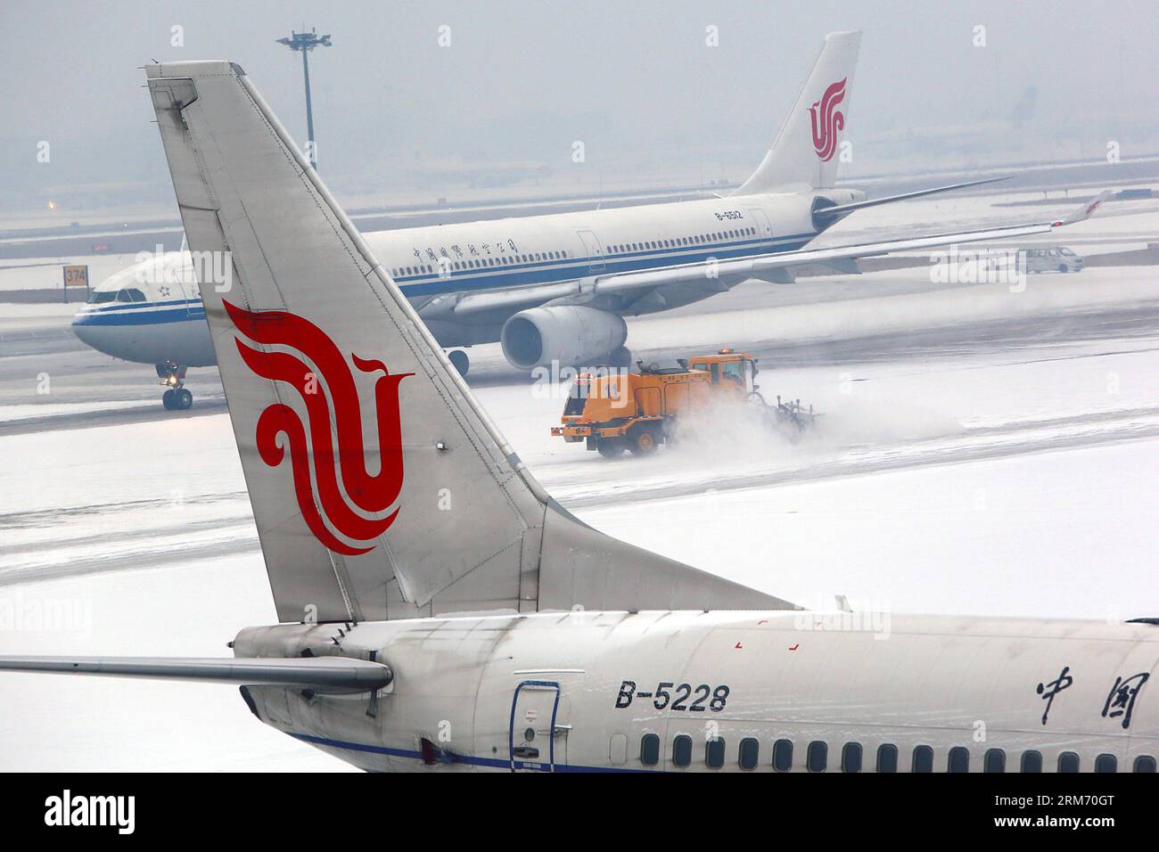 (140207) -- BEIJING, Feb. 7, 2014 (Xinhua) -- A deicing vehicle clears snow on a taxiway at the Beijing Capital International Airport in Beijing, capital of China, Feb. 7, 2014. Snow made its debut of this winter in Beijing on Friday, putting pressure on air traffic during the passenger flow return peak after a week-long lunar new year holiday. (Xinhua/Jing Lei) (cjq) CHINA-BEIJING-SNOWFALL-FLIGHT (CN) PUBLICATIONxNOTxINxCHN   Beijing Feb 7 2014 XINHUA a Deicing Vehicle clear Snow ON a Taxiway AT The Beijing Capital International Airport in Beijing Capital of China Feb 7 2014 Snow Made its Deb Stock Photo