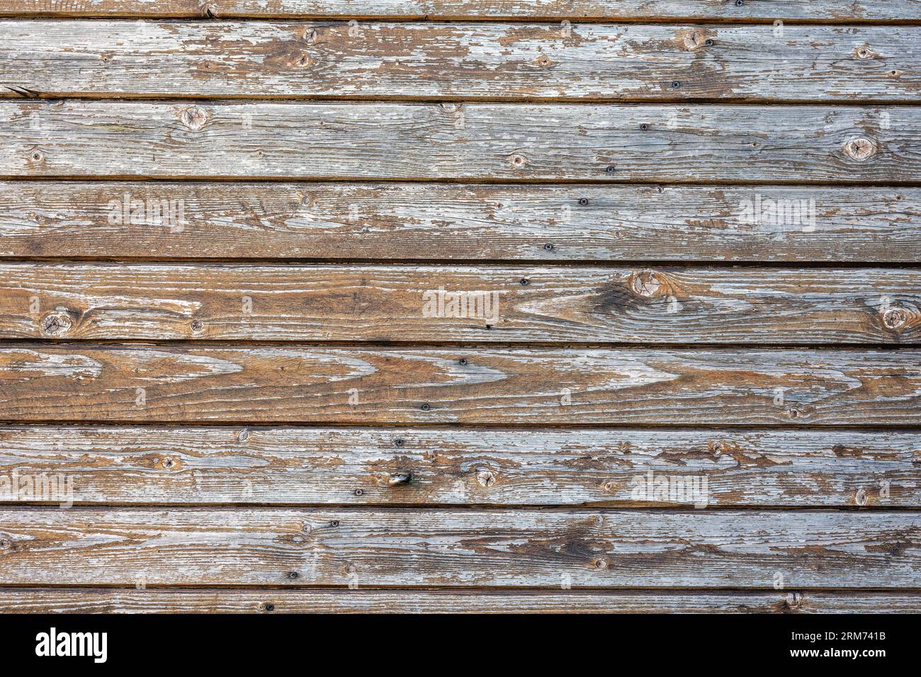 Background from a worn brown plank wall with flaking paint Stock Photo