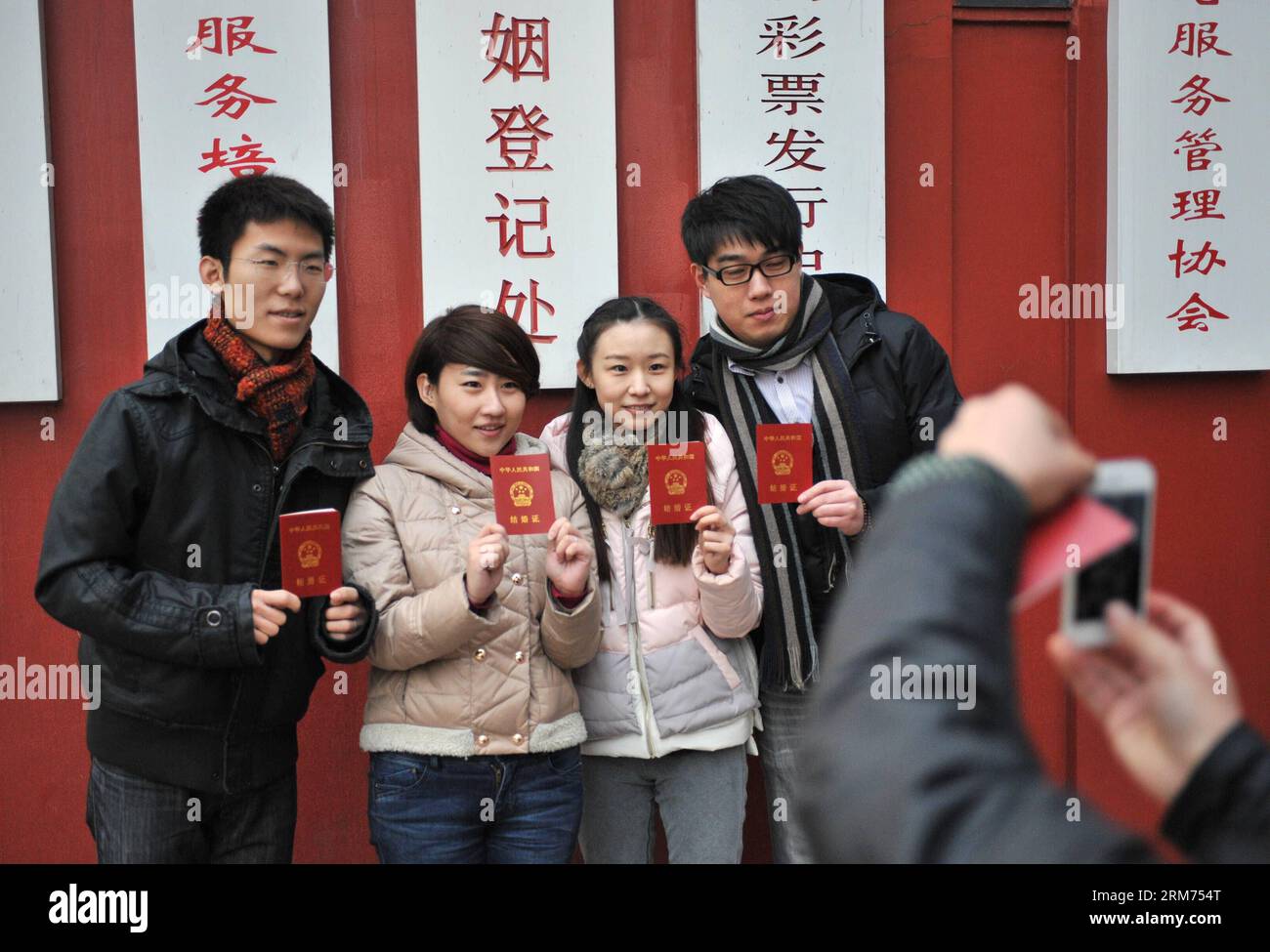 (140214) -- BEIJING, Feb. 14, 2014 (Xinhua) -- Newlyweds holding their certificates pose for photos at a marriage registry on the Valentine s Day as well as the Chinese traditional Lantern Festival in Beijing, capital of China, Feb. 14, 2014. Many newlyweds chose to get marriage licenses on the Valentine s Day this year, as it coincides with the Lantern Festival, the 15th day of the first month of the Chinese lunar calendar. (Xinhua/Sun Ruibo) (lfj) CHINA-VALENTINE S DAY-MARRIAGE REGISTRATION (CN) PUBLICATIONxNOTxINxCHN   Beijing Feb 14 2014 XINHUA Newlyweds Holding their certificates Pose for Stock Photo