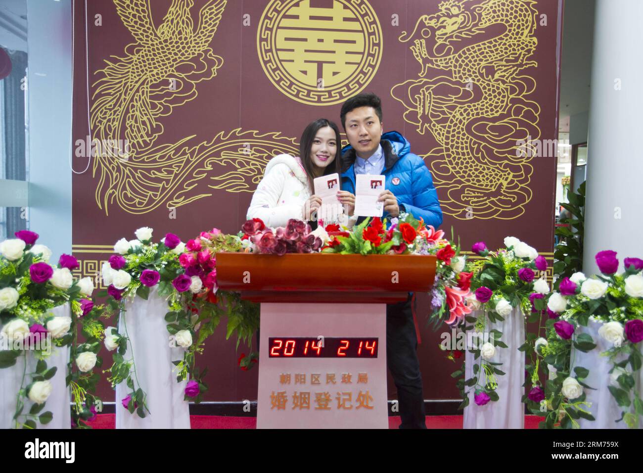 (140214) -- BEIJING, Feb. 14, 2014 (Xinhua) -- Newlyweds holding marriage certificates pose for photos at a marriage registry on the Valentine s Day as well as the Chinese traditional Lantern Festival in Beijing, capital of China, Feb. 14, 2014. Many newlyweds chose to get marriage licenses on the Valentine s Day this year, as it coincides with the Lantern Festival, the 15th day of the first month of the Chinese lunar calendar. (Xinhua/Zhao Bing) (lfj) CHINA-VALENTINE S DAY-MARRIAGE REGISTRATION (CN) PUBLICATIONxNOTxINxCHN   Beijing Feb 14 2014 XINHUA Newlyweds Holding MARRIAGE certificates Po Stock Photo