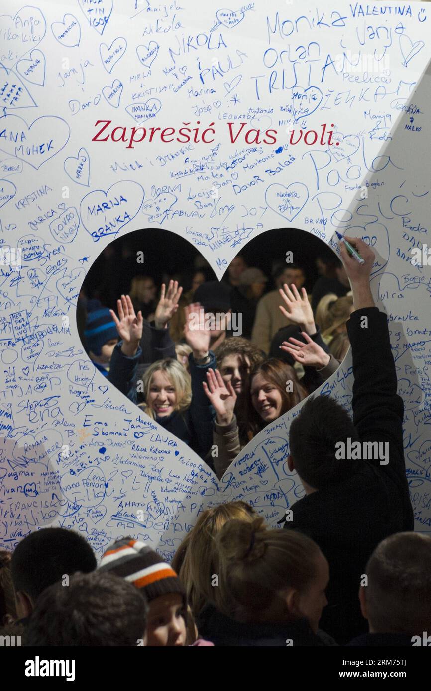 A man signs his name on a huge Valentine s Day card during the Lampionovo Lantern Festival in Zapresic, Croatia, Feb. 14, 2014. People released lanterns carrying their hopes and best wishes during the festival on Friday, and signed a huge Valentine s Day card to their twin town of Kastela. (Xinhua/Miso Lisanin) (zhf) CROATIA-ZAPRESIC-LANTERN FESTIVAL PUBLICATIONxNOTxINxCHN   a Man Signs His Name ON a Huge Valentine S Day Card during The  Lantern Festival in  Croatia Feb 14 2014 Celebrities released Lanterns carrying their Hopes and Best wishes during The Festival ON Friday and signed a Huge Va Stock Photo