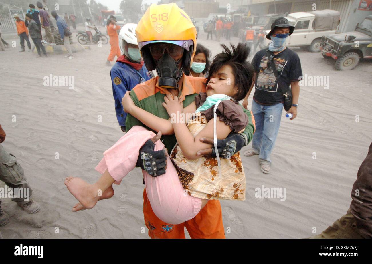 (140215) -- MALANG, Feb. 15, 2014 (Xinhua) -- A rescuer evacuates a girl after the eruption of Mount Kelud at Malang in East Java, Indonesia, on Feb. 15, 2014. Indonesia has closed seven airports as the Mount Kelud volcano in East Java remains on top alert after its eruption Thursday night, though tens of thousands of evacuees have returned home, an official said here Saturday. (Xinhua/Hidayat) INDONESIA-MALANG-MOUNT KELUD-EVACUATION PUBLICATIONxNOTxINxCHN   Malang Feb 15 2014 XINHUA a Rescuer evacuates a Girl After The Eruption of Mount Kelud AT Malang in East Java Indonesia ON Feb 15 2014 In Stock Photo