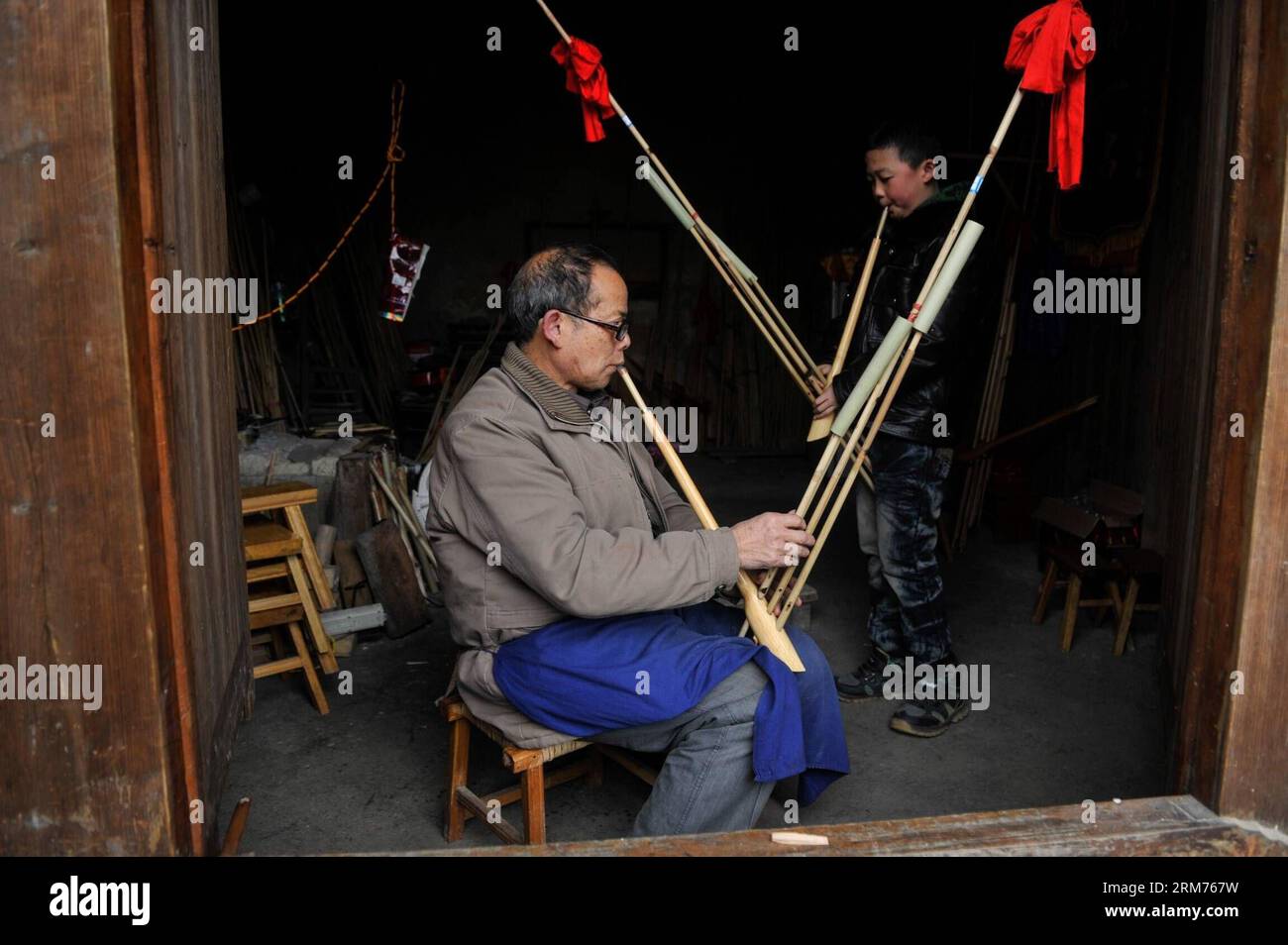 (140215) -- KAILI, Feb. 15, 2014 (Xinhua) -- Craftsman Pan Rouda tries a newly-made Lusheng, a kind of reed-pipe wind instrument, in Xin guang Village, Zhouxi Township, Qiandongnan Miao and Dong Autonomous Prefecture of southwest China s Guizhou Province, Feb. 15, 2014. Dubbed as the home of Lusheng , Xin guang has the tradition of making the wind instrument for some 400 years with 65 family workshops still making it at present. In the year of 2006, China listed the craft as the national intangible cultural heritage. (Xinhua/Ou Dongqu) (hdt) CHINA-GUIZHOU-LUSHENG (CN) PUBLICATIONxNOTxINxCHN Stock Photo