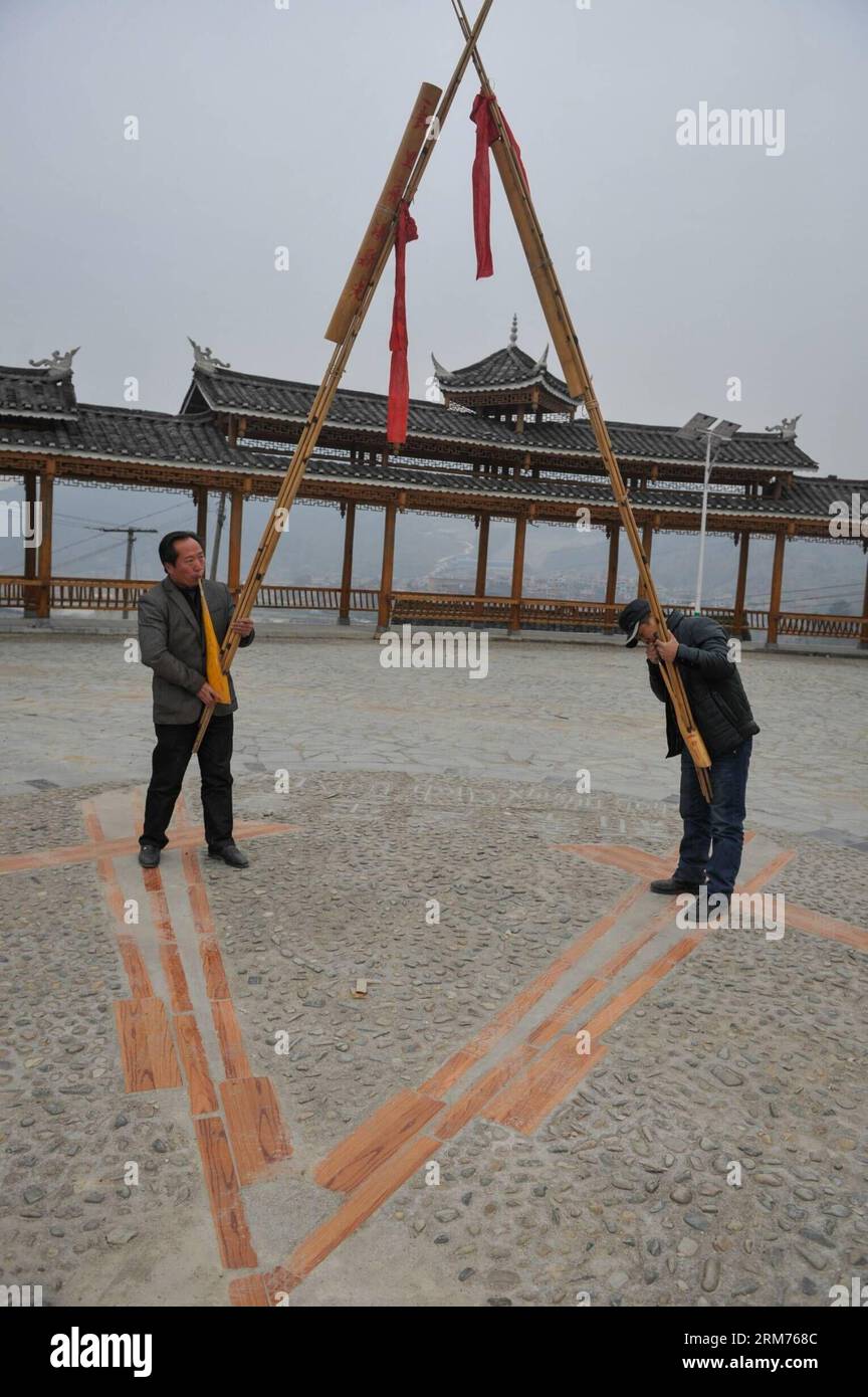 (140215) -- KAILI, Feb. 15, 2014 (Xinhua) -- Pan Guisheng (L), head of the Lusheng promotion association of Xin guang Village, plays a three-meter-long Lusheng, a kind of reed-pipe wind instrument, in the village, Zhouxi Township, Qiandongnan Miao and Dong Autonomous Prefecture of southwest China s Guizhou Province, Feb. 15, 2014. Dubbed as the home of Lusheng , Xin guang has the tradition of making the wind instrument for some 400 years with 65 family workshops still making it at present. In the year of 2006, China listed the craft as the national intangible cultural heritage. (Xinhua/Ou Dong Stock Photo