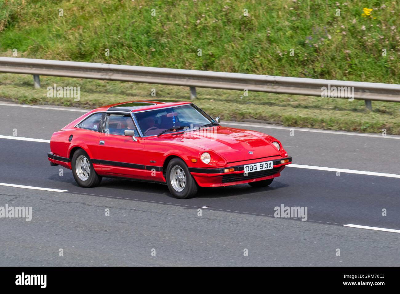 1982 80s eighties Red Datsun 280 Zx Targa Auto Petrol 2753 cc, Z-car coupe; travelling at speed on the M6 motorway in Greater Manchester, UK Stock Photo