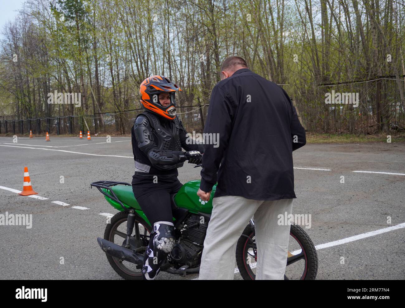 Pretty girl in a jacket sits on a purple motorbike with a red and black  safety helmet Stock Photo by fxquadro