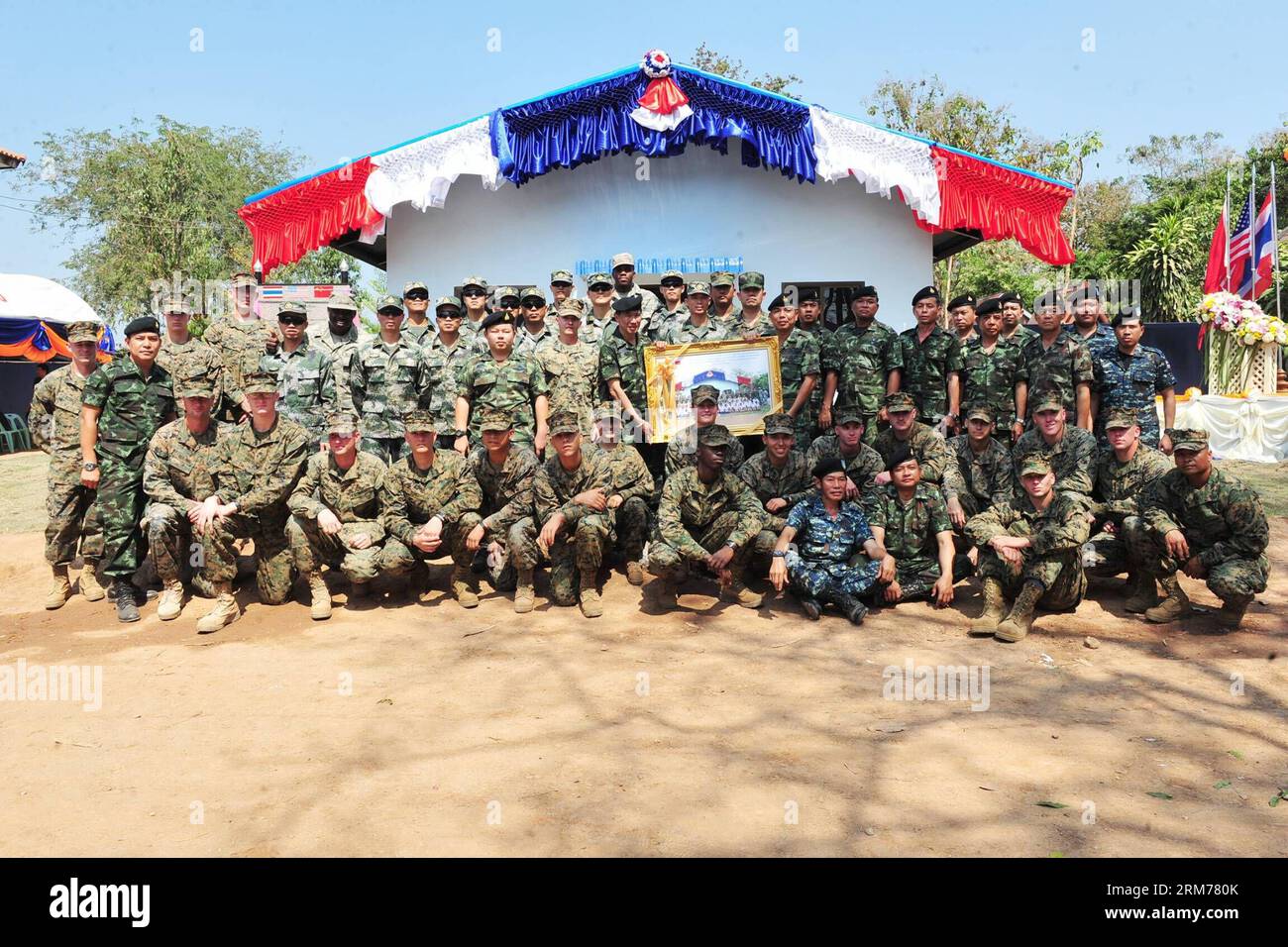 (140218) -- PITSANULOKE, Feb. 18, 2014 (Xinhua) -- Chinese , Thai and U.S. soldiers pose for a group photo during the exercise Cobra Gold 2014 at a school in Pitsanuloke Province, Thailand, Feb. 18, 2014. China has sent troops to attend the multilateral military exercise Cobra Gold, led by the United States and Thailand, for the first time. The seventeen-strong Chinese squad will take part in operations at the command and coordination center, engineering assistance, medical aid as well as discussions and exchanges of military medical sciences, according to officers with the foreign affairs off Stock Photo